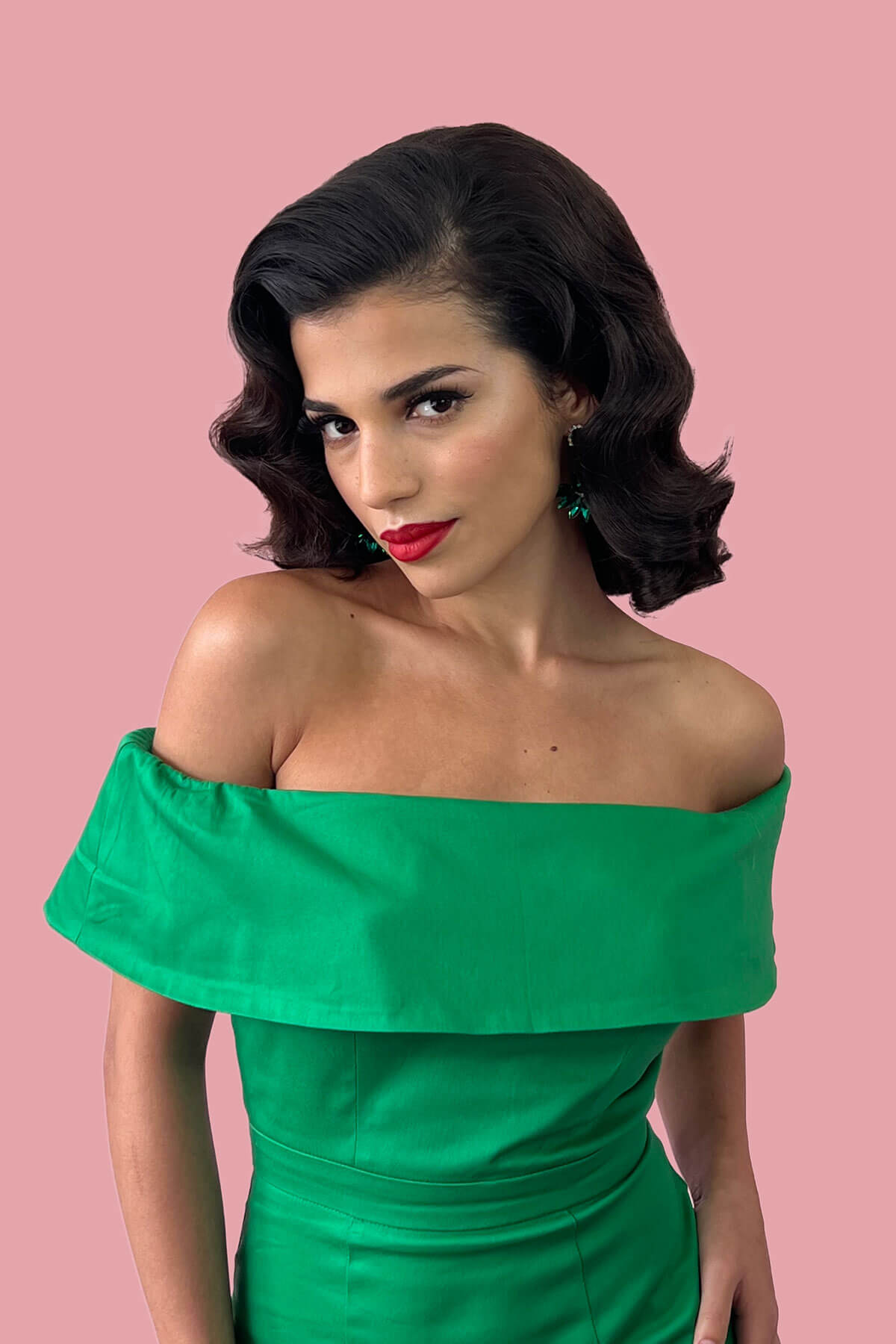 Woman with gorgeous vintage wave hair wearing a green off-shoulder dress against a pink background. 1940s style half wig hairpiece with beautiful marcel waves: Virginia dark brown 4