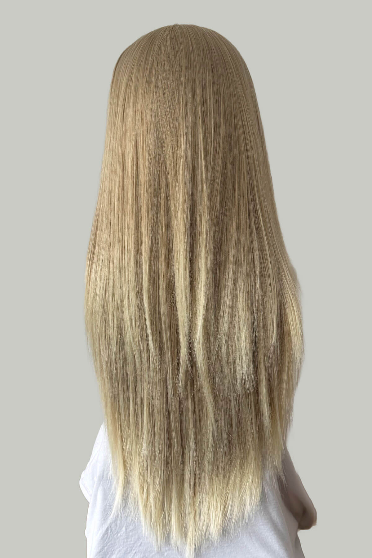 Long blonde hair on a plain background. Straight blonde half wig hairpiece (3/4 wig): Tabitha blonde 613T24