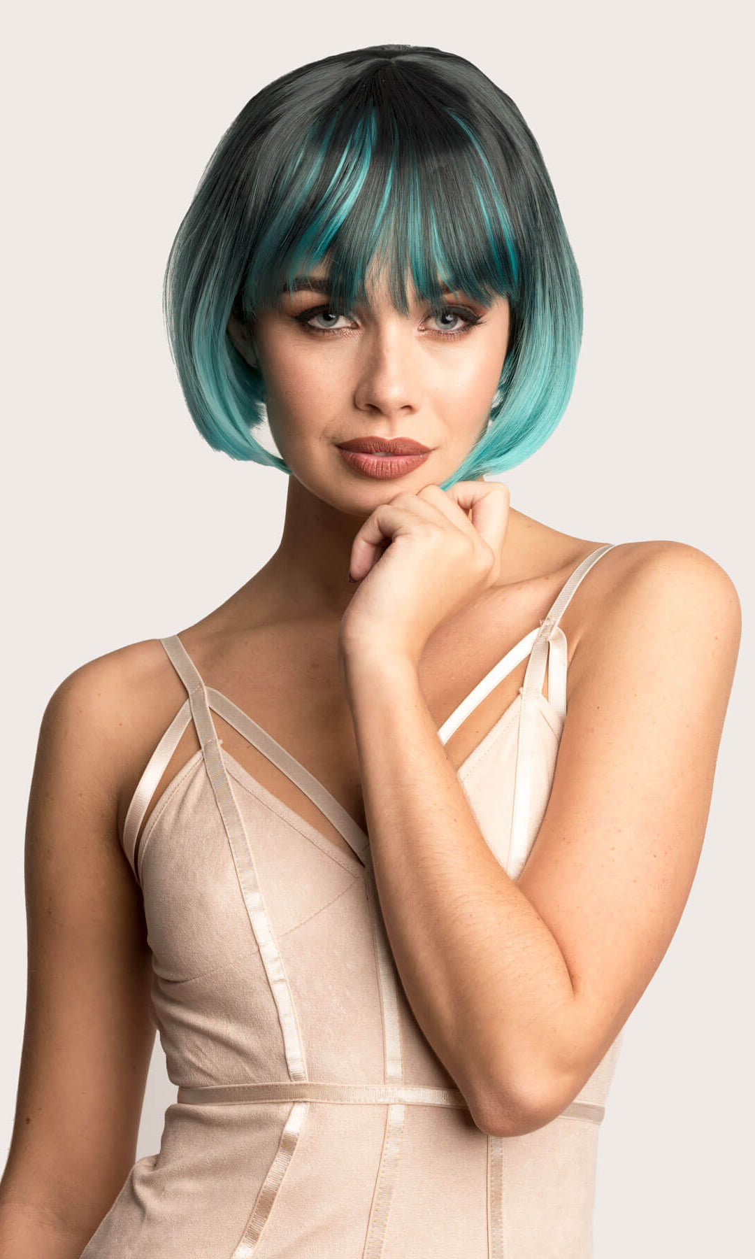 Woman with a stylish haircut and makeup on a plain background. Bob wig, black ombre blending to turquoise blue: Amara
