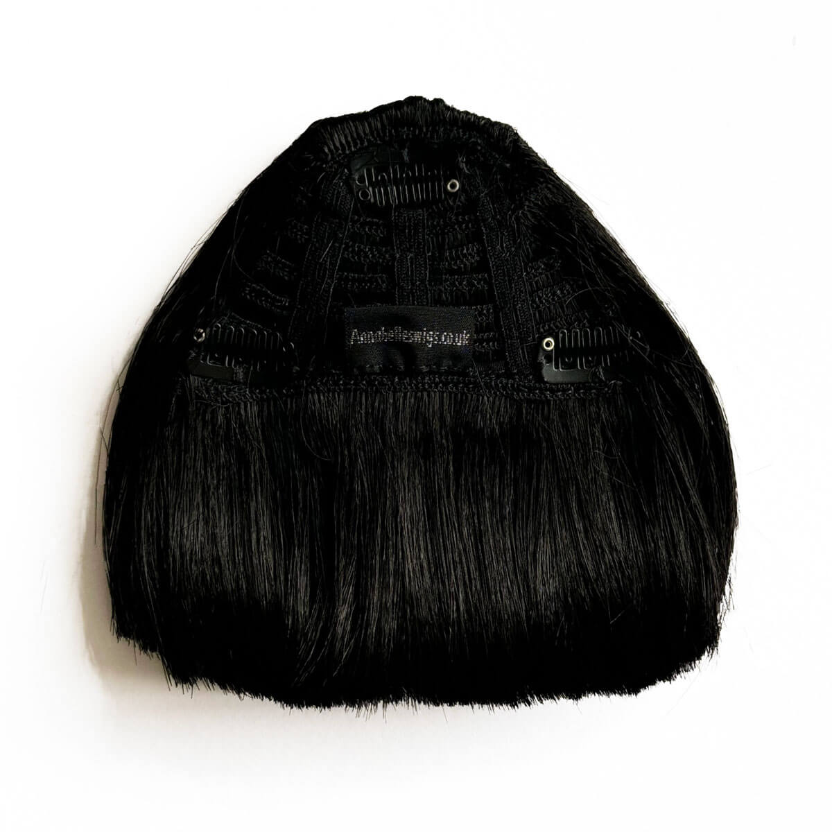 Black fringe hair piece on a white background