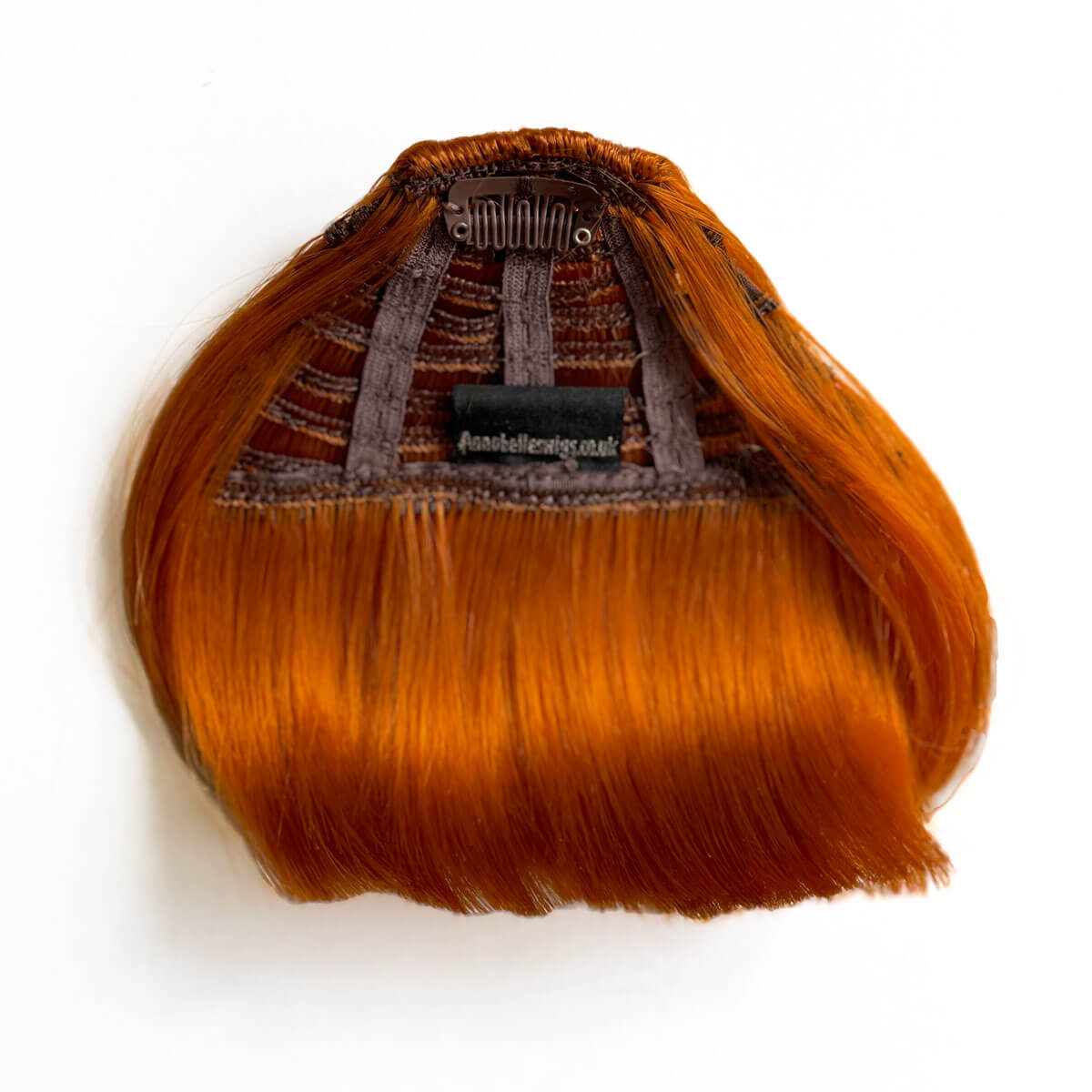 Orange hair extension with brown clip on a white background. Clip-in fringe hairpiece/clip-in micro-bangs, thick, straight retro rockabilly style: Ida ginger