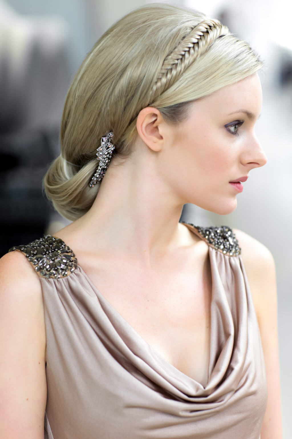 Woman with elegant hair and jewelery wearing a beige dress. Fishtail plait hairband (braid) blonde 24H613