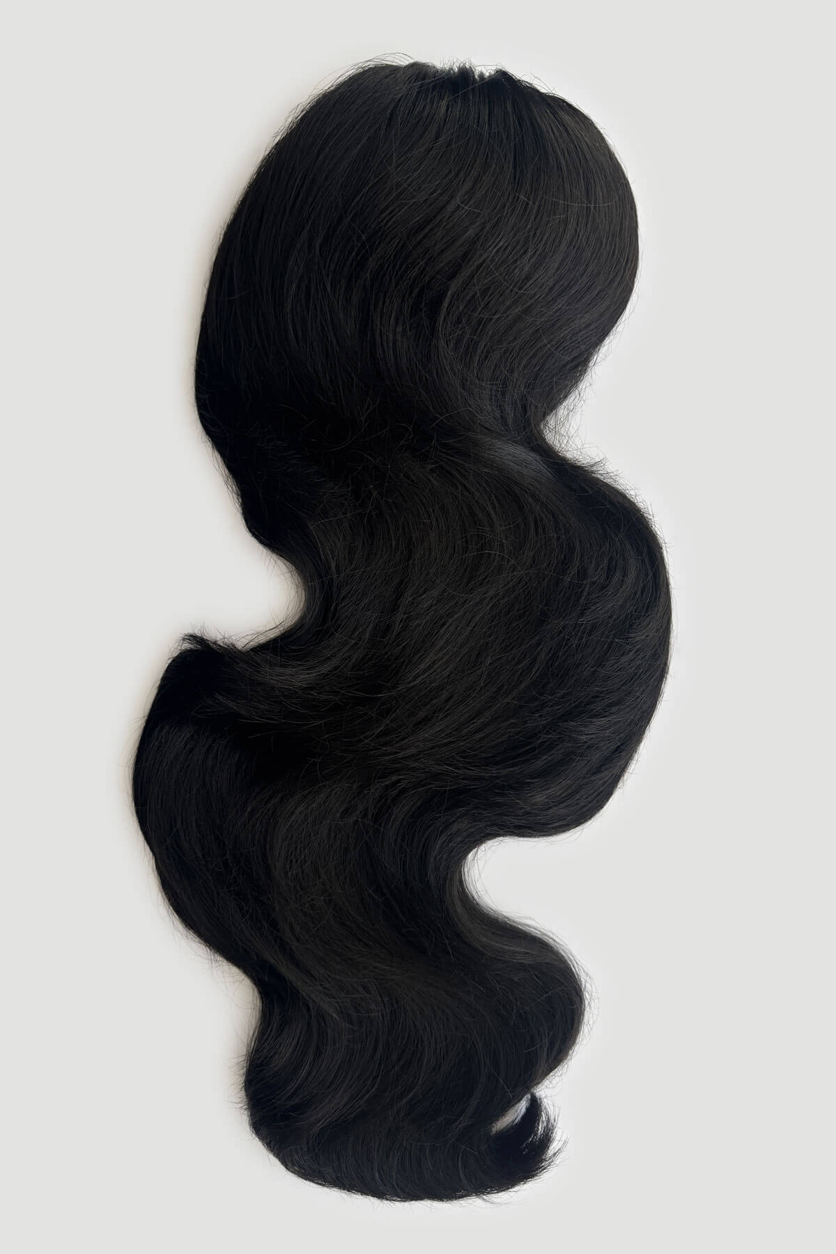 Black wavy hair extension hair piece, displayed against a light grey background. Double volume hairpiece extension: Naomi black 1B