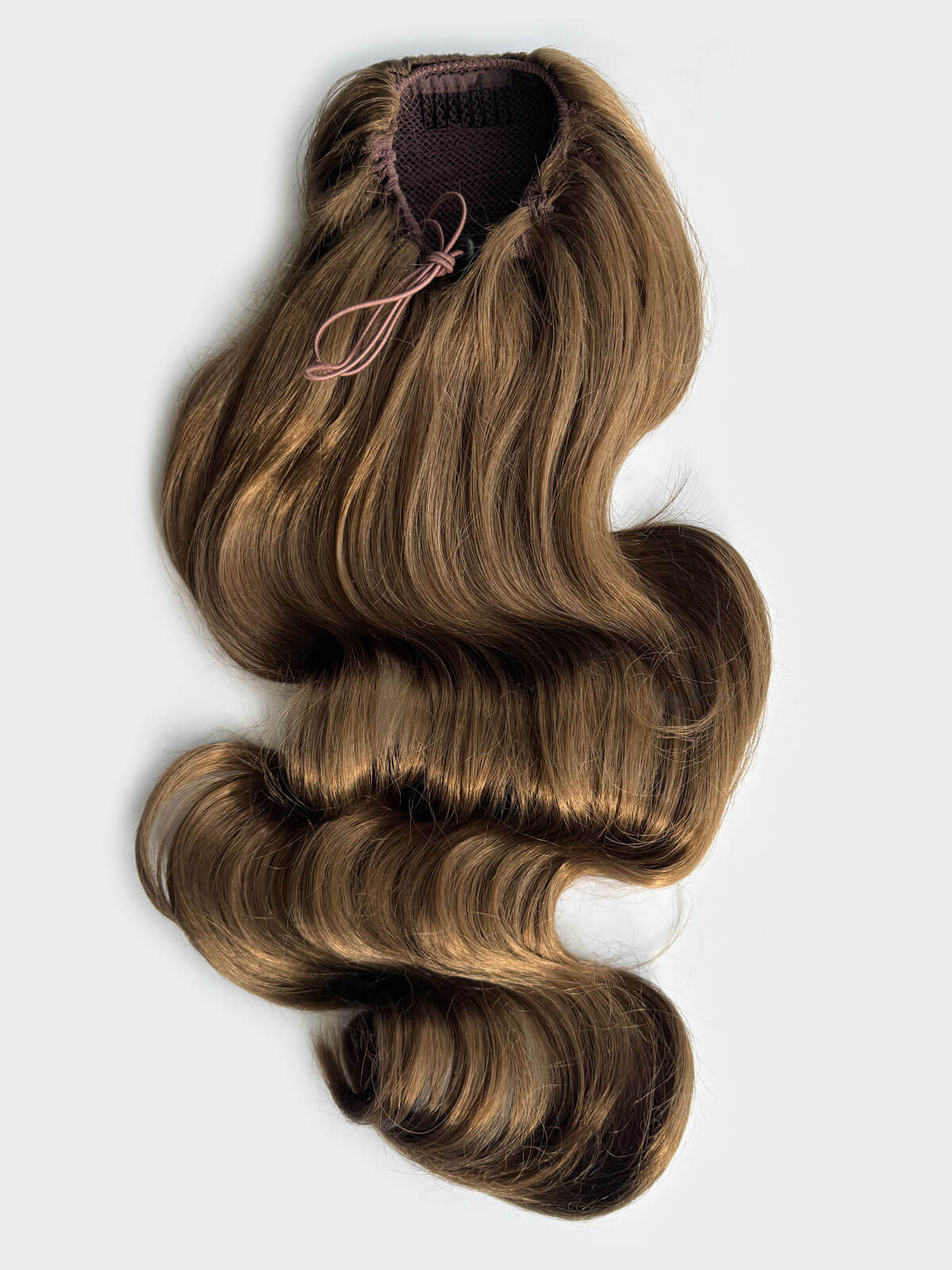 Brown hair extension with draw string attachment on a light grey background. Double volume hairpiece extension: Naomi mocha brown 10