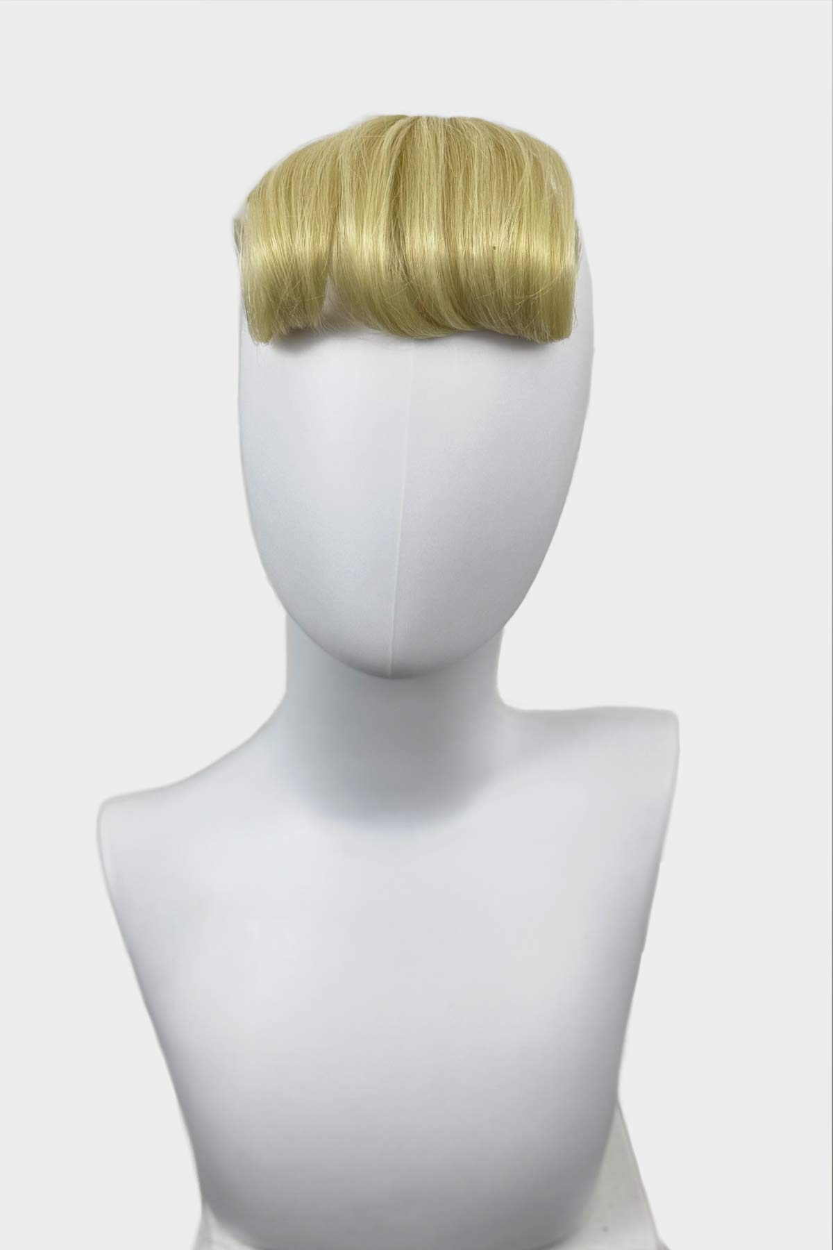 Blonde hair extension on a mannequin head against a white background. Victory roll fringe/bangs hairpiece, 1950s vintage style: Rosa light blonde 613