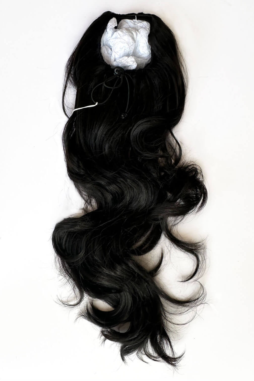 Black wavy hair extensions on a white background. Double volume hairpiece extension: Naomi black 1B