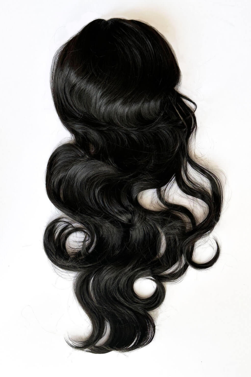 Black hair extensions with wavy texture on a white background. Double volume hairpiece extension: Naomi black 1B