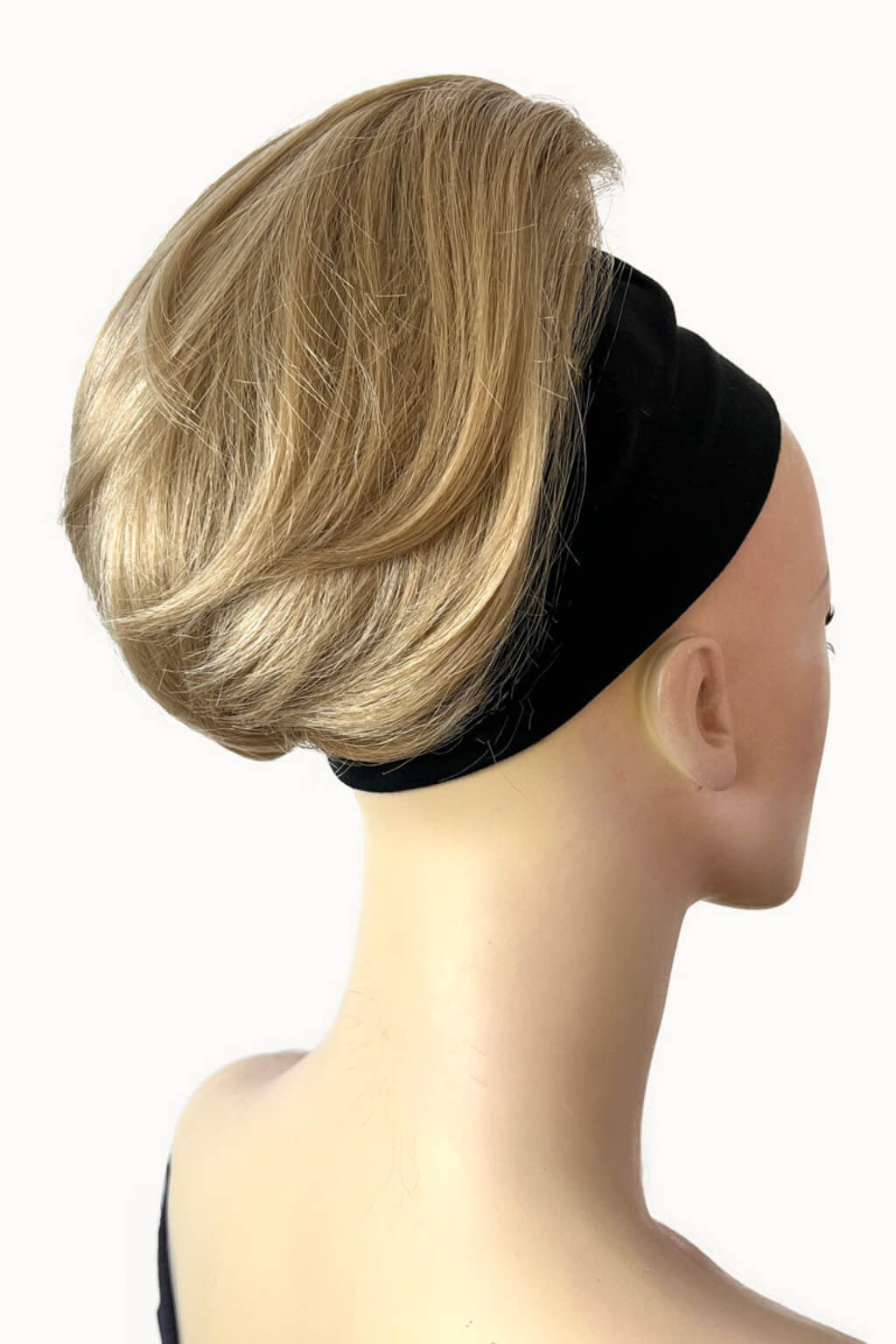 A blonde faux hairpiece styled in a low, voluminous hair piece with a black headband, shown on a mannequin head from the back against a plain white background. Short ponytail extension hairpiece, straight, full & bouncy: Tanaya blonde 24H613