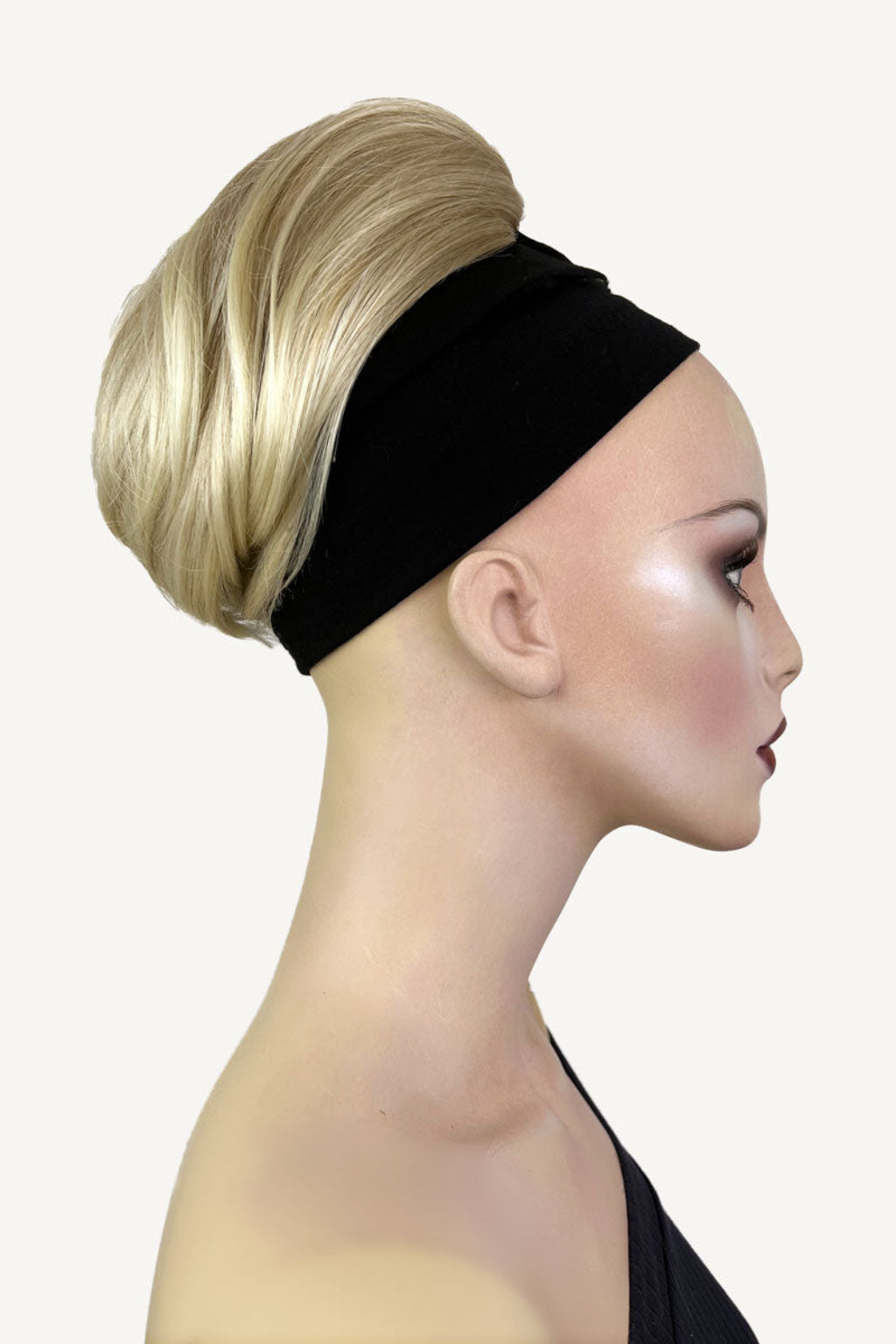 A woman wearing a white halter neck top showcasing a short ponytail extension hairpiece in a straight, full, and bouncy style. Short ponytail extension hairpiece, straight, full & bouncy: Tanaya blonde 613T24