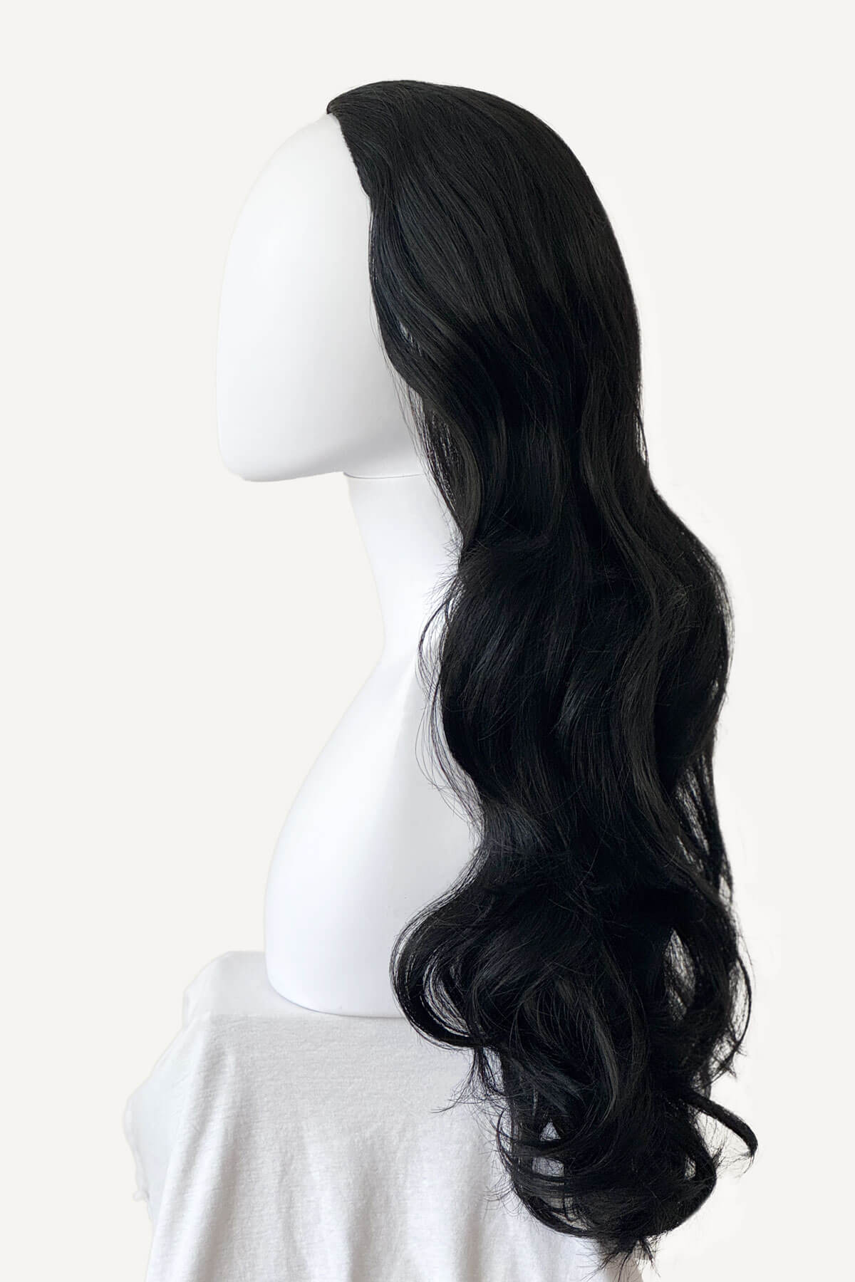 Black wig on a mannequin head against a white background. Black curly half wig hairpiece (volume wig), big loose curls: Suzie