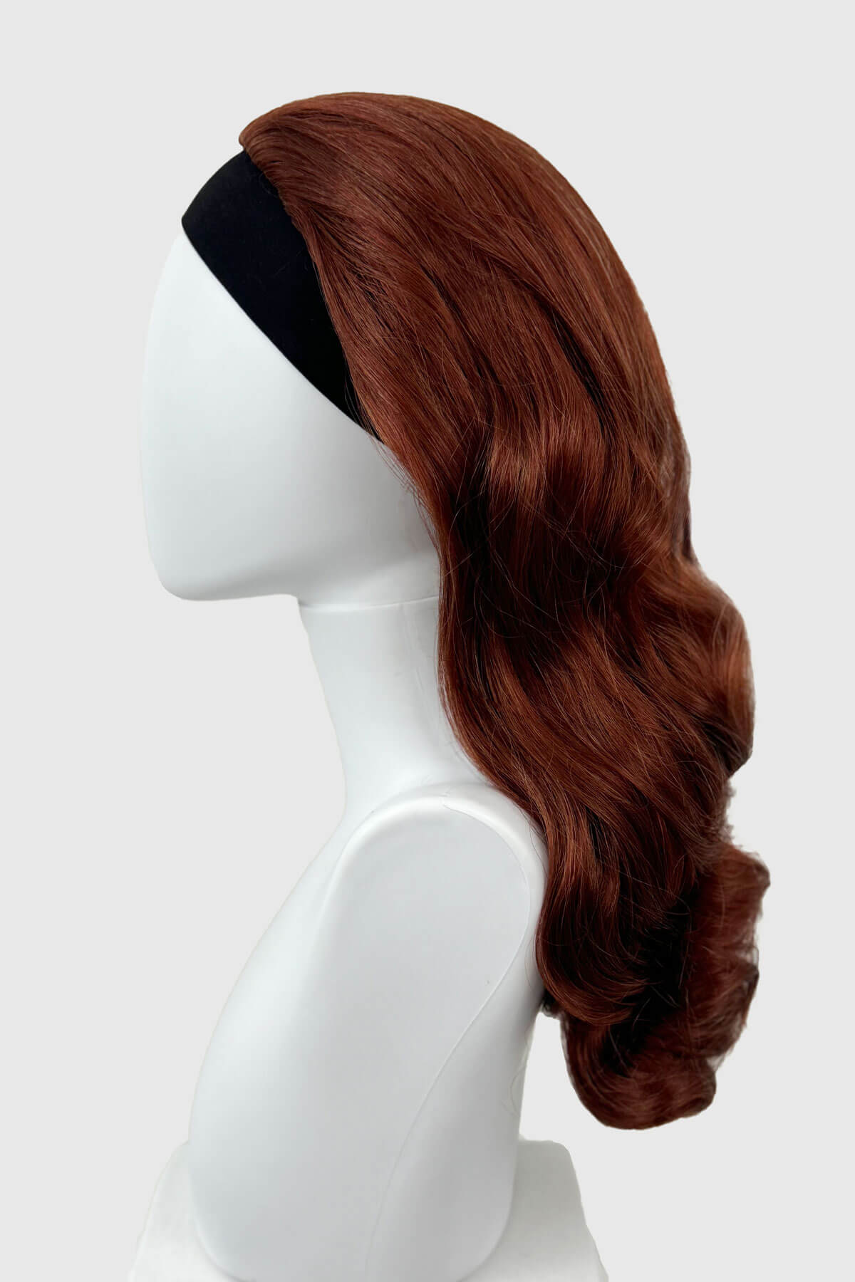 Copper red wig on a white mannequin head against a white background. 1950s style half wig hairpiece with beautiful waves: Morgana copper red 130