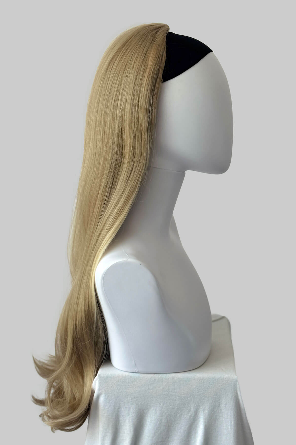 Mannequin head with ash blonde half wig on a plain background. Kate - Heat Styleable Extra Long, Gentle Wave Half Wig blonde 24H613