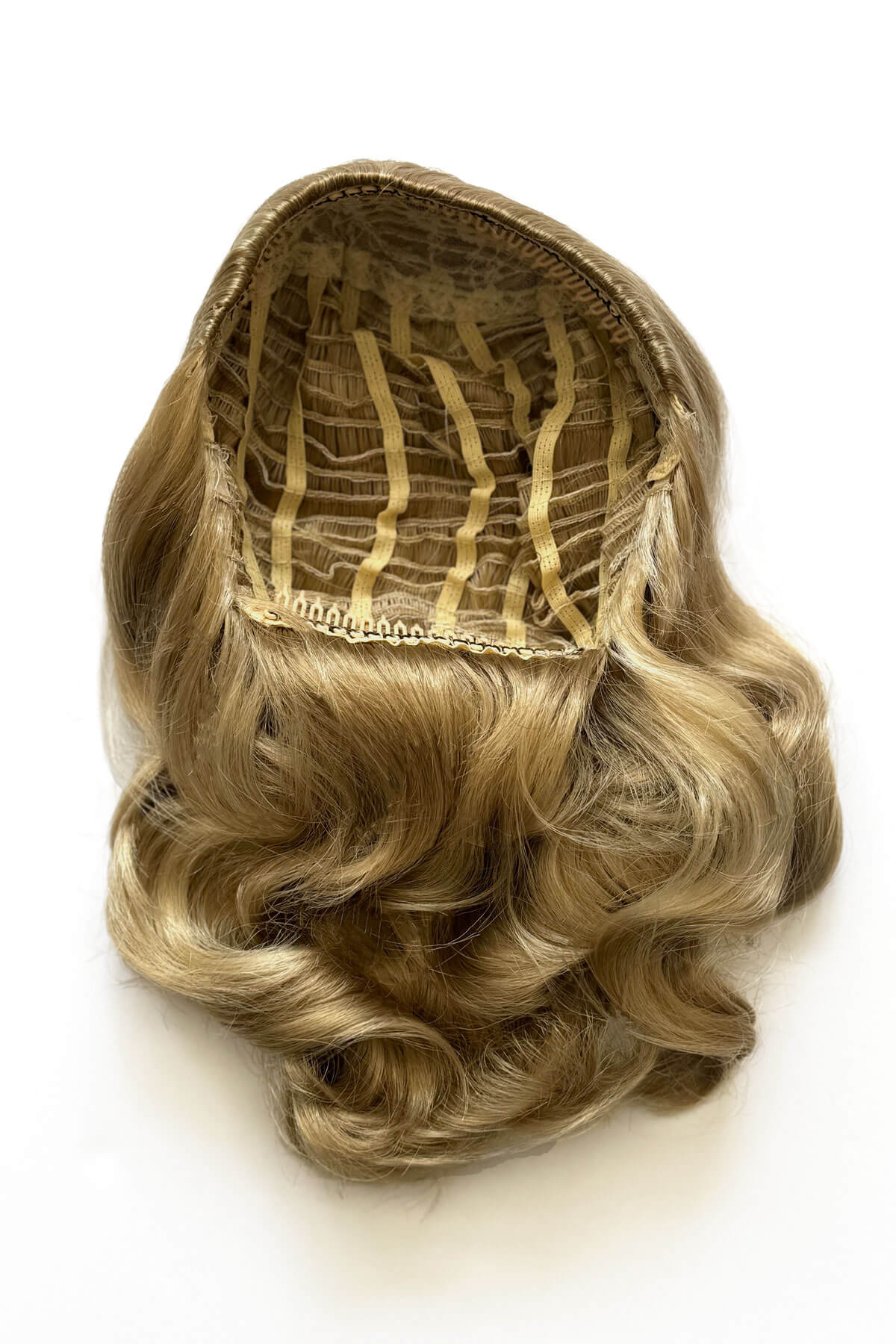 Blonde hairpiece on a white background. 1950s style shoulder length half wig hairpiece with beautiful vintage waves: Onyx blonde 24H613