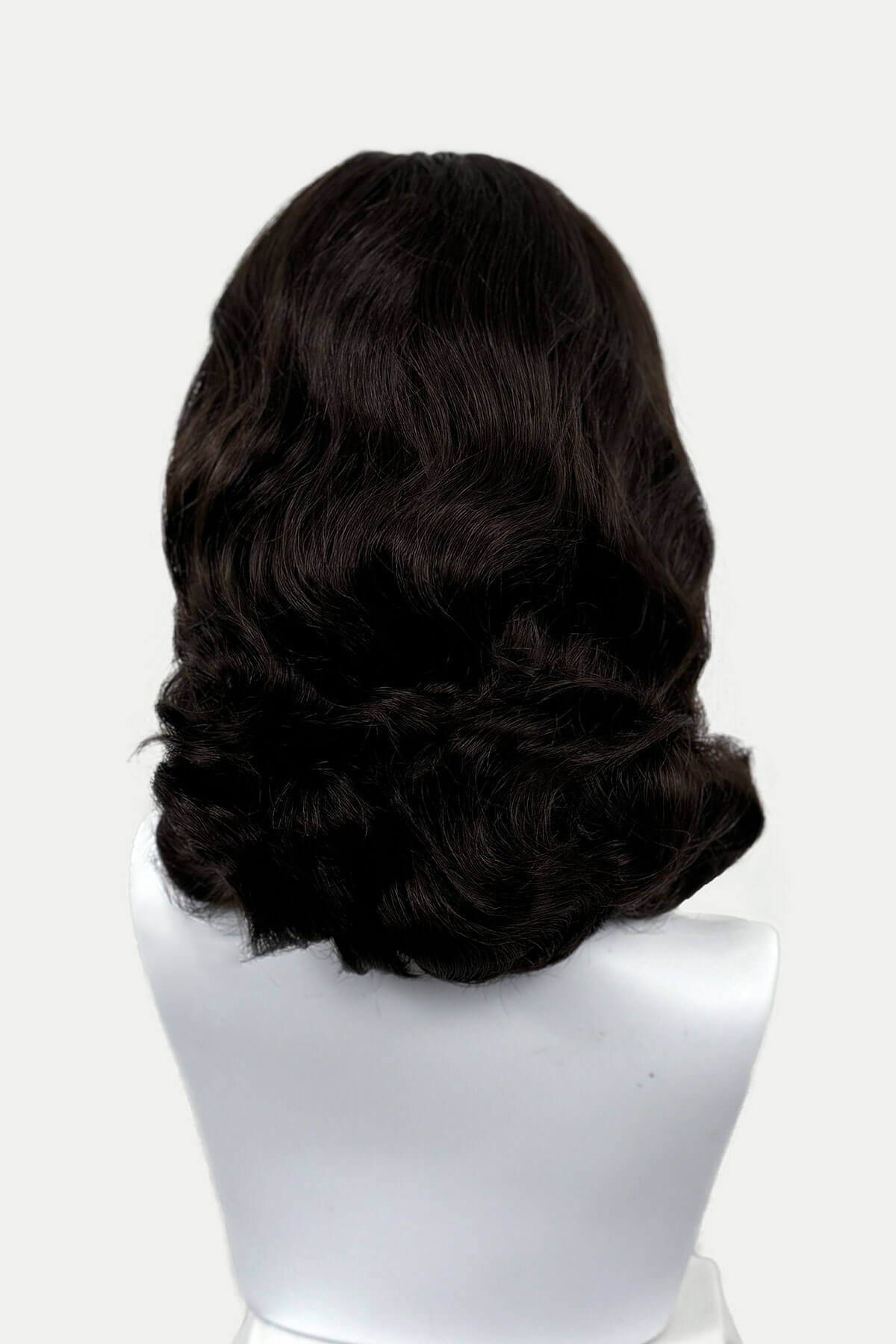 Dark chocolate brownwig on a mannequin head against a white background viewed from the back. 1950s style shoulder length half wig hairpiece with beautiful vintage waves: Onyx dark chocolate brown 6