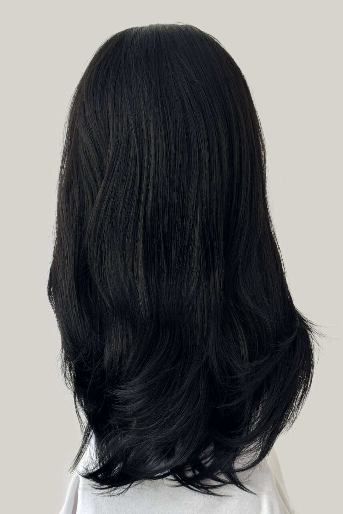 Black wig on a neutral background. Straight black half wig hairpiece, layered: Cerys