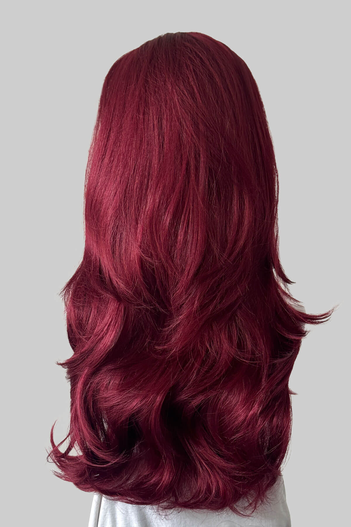 Long, wavy burgundy red half wig, shown from the back against a solid grey background. Claudia - Volume Boosting Long Gentle Bouncy Layered Half wig dark cherry red 39