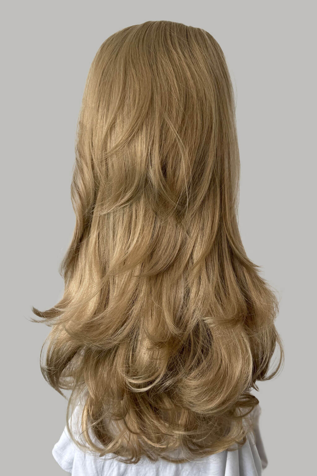 Blonde wig with wavy hair on a gray background - High crown long, layered half wig and volume ring: Helena blonde 24H613