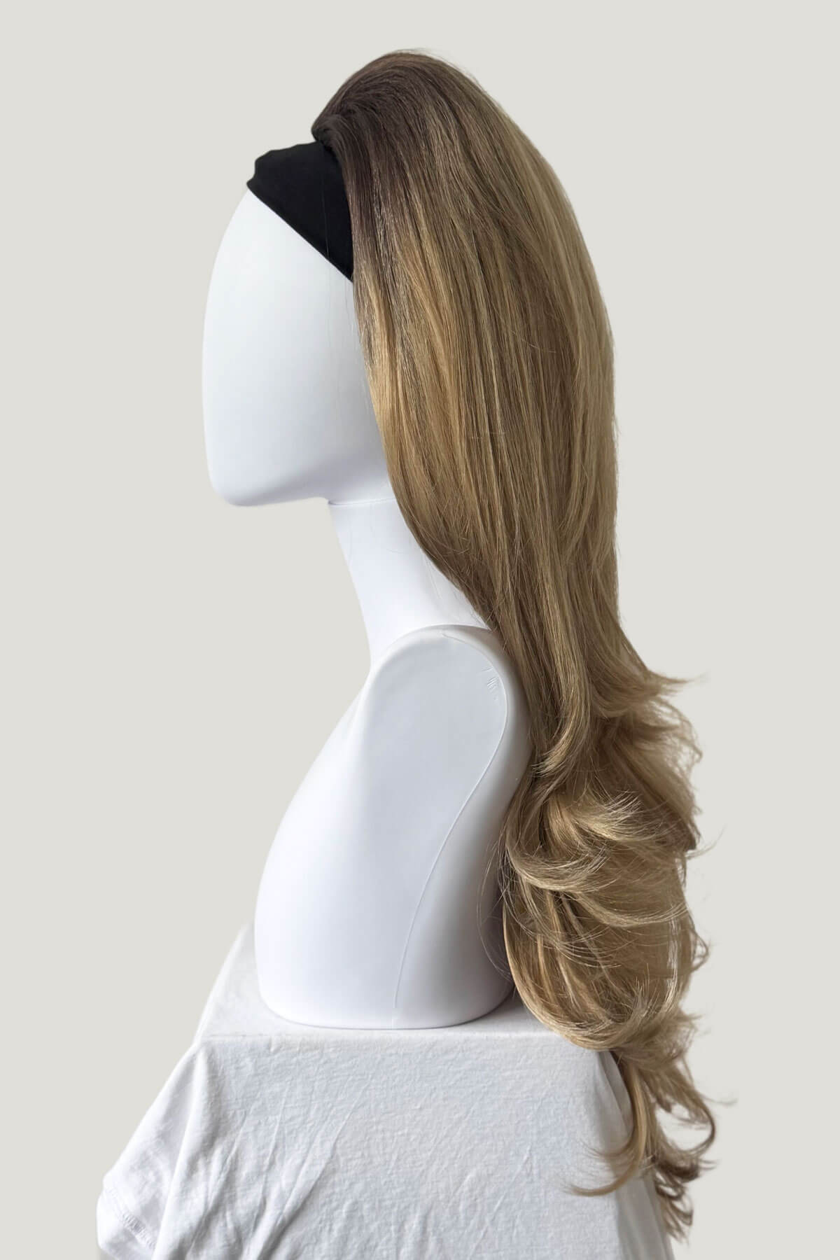Long wig on a mannequin head against a plain background. High crown long, layered half wig and volume ring: Helena brown to blonde 8TN24