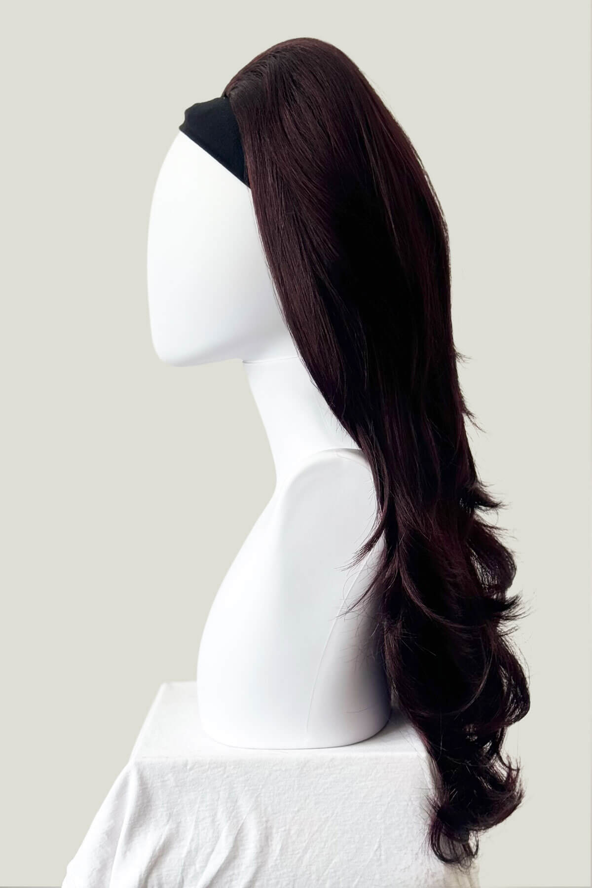Dark wig on a mannequin head against a plain background. High crown long, layered half wig and volume ring: Helena black and purple 99J