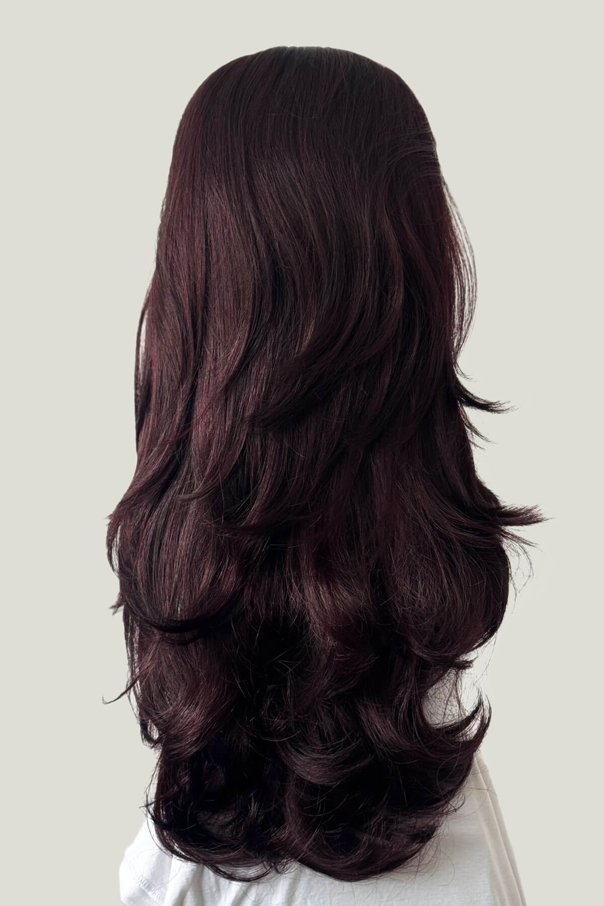 Long, dark brown wig on a white background. High crown long, layered half wig and volume ring: Helena black and purple 99J