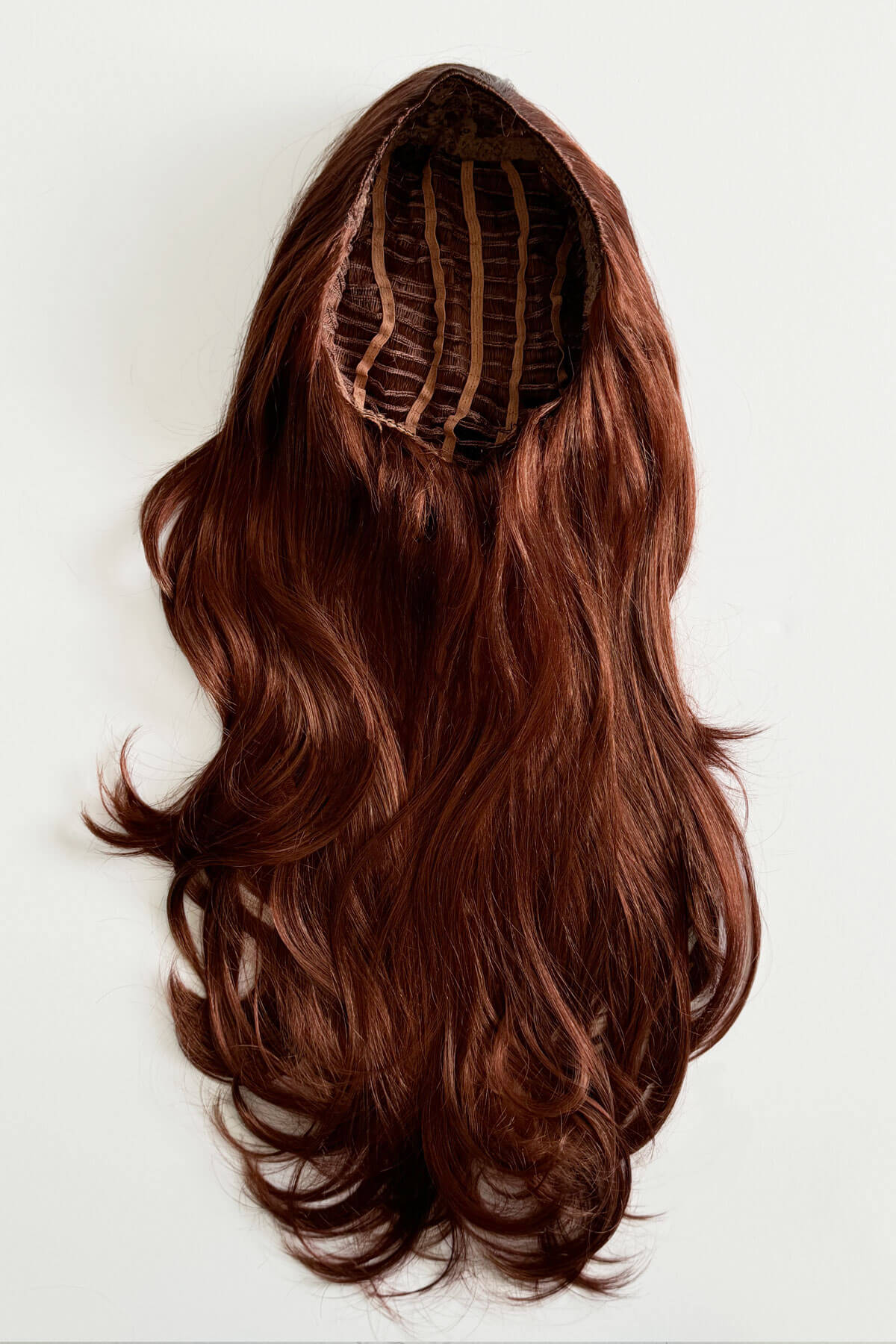 Brown hair extension on a white background. Red half wig hairpiece (3/4 wig), gentle curls: Ivy copper 130