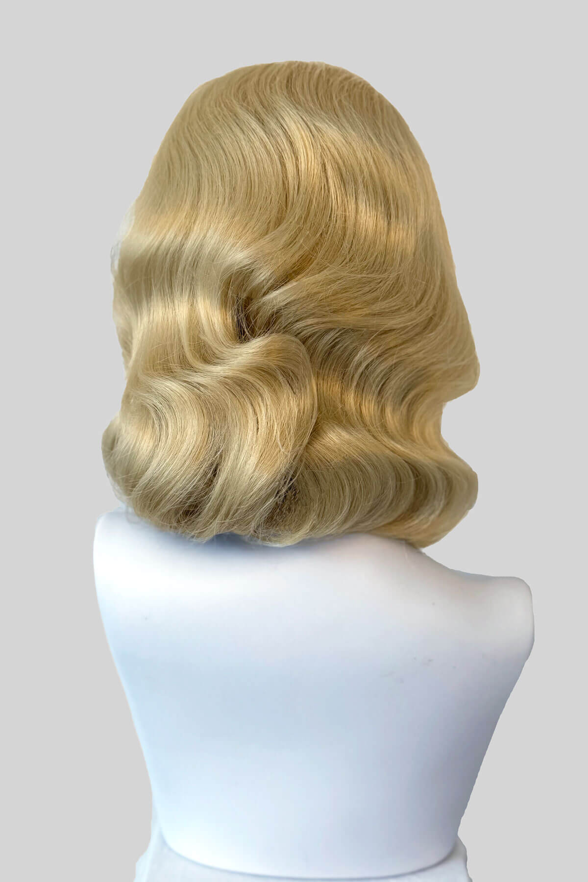 Mannequin with vintage style wig with marcel waves on it, from the back. 1940s style half wig hairpiece with beautiful marcel waves: Virginia creamy blonde 613