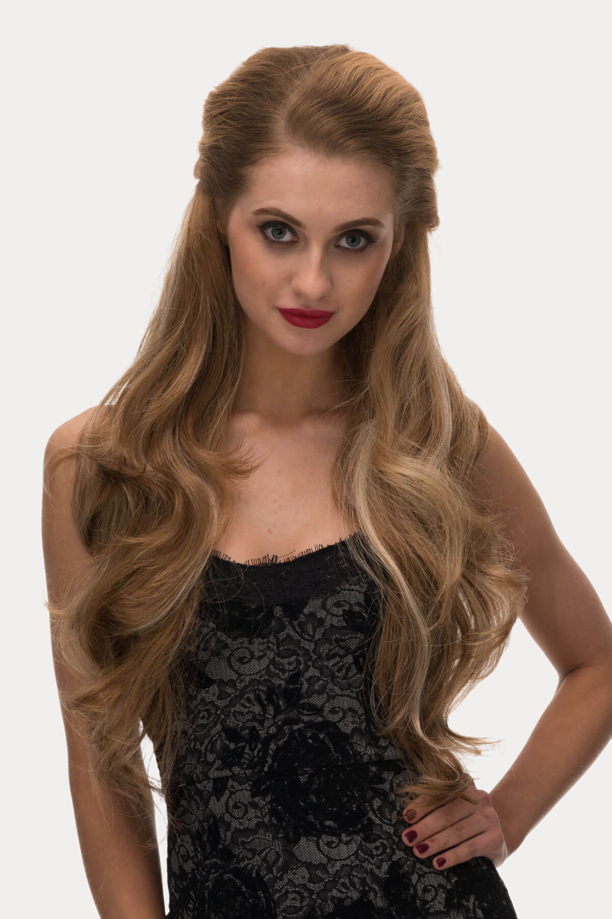 Woman with long, wavy hair wearing a black dress on a white background. Light brown half wig with blonde highlights & loose waves: May