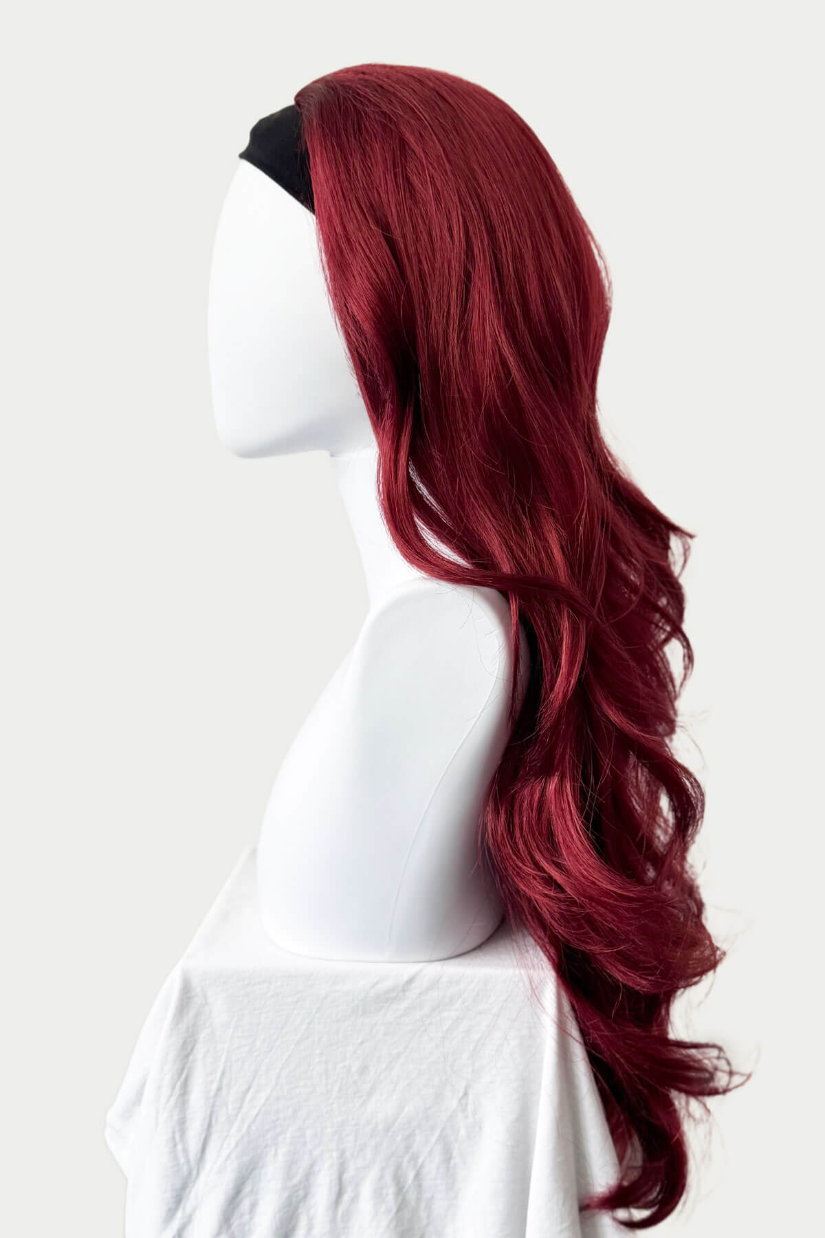 Red wig on a mannequin head against a white background. Red half wig (3/4 hairpiece) with long waves: Sasha wine red and copper red 350-39