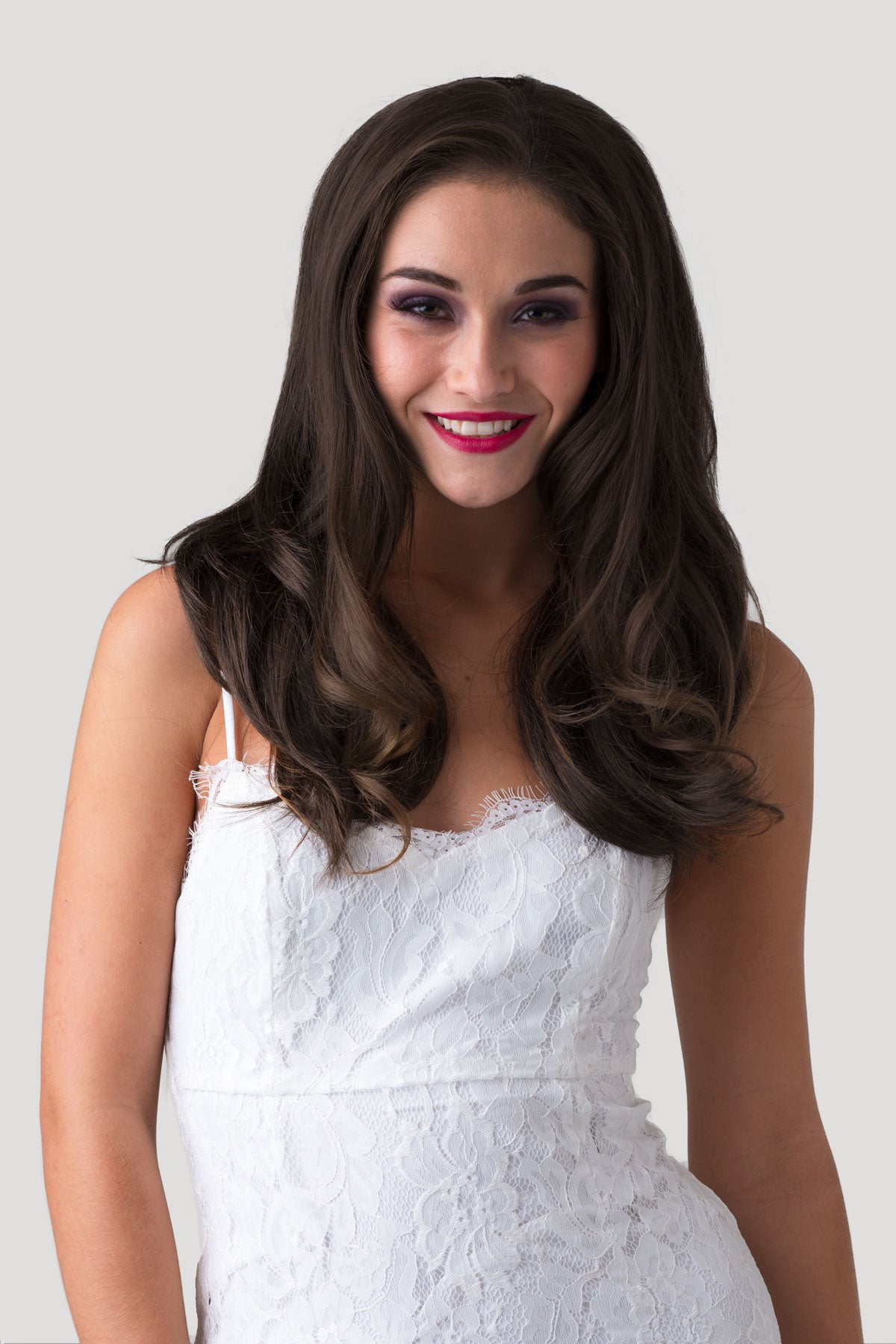 Woman wearing a white lace dress against a plain background. Brown half wig hairpiece (3/4 wig), gently layered: Briar chestnut brown 8