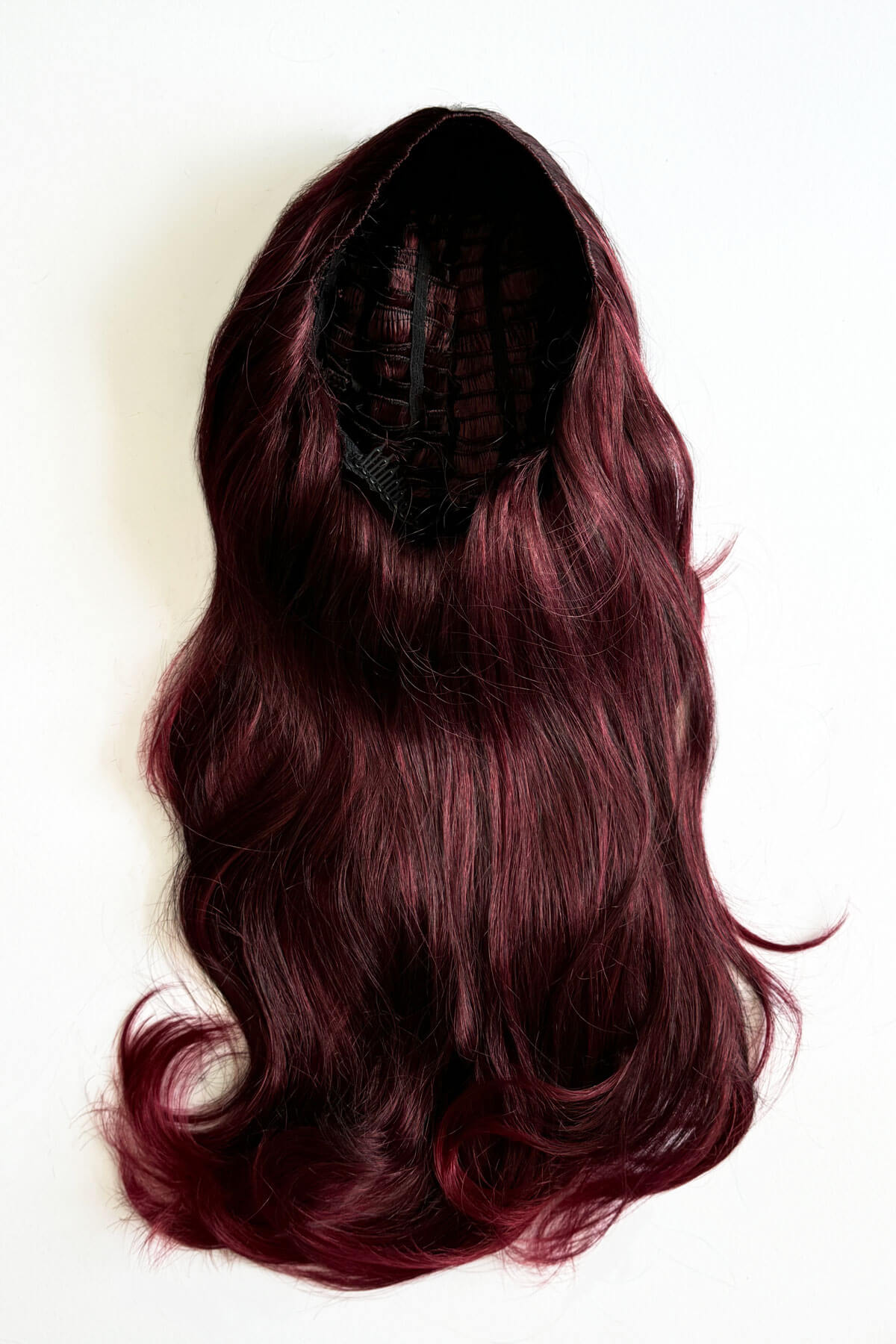 Purple hair extension on a white background. Black and red half wig hairpiece (3/4 wig), loose curls: Monica