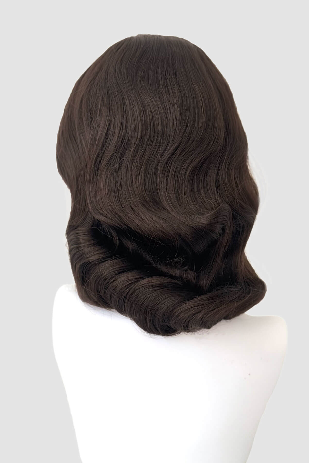 Dark brown wig on a white mannequin head against a light grey background. 1940s style half wig hairpiece with beautiful marcel waves: Virginia dark brown 6