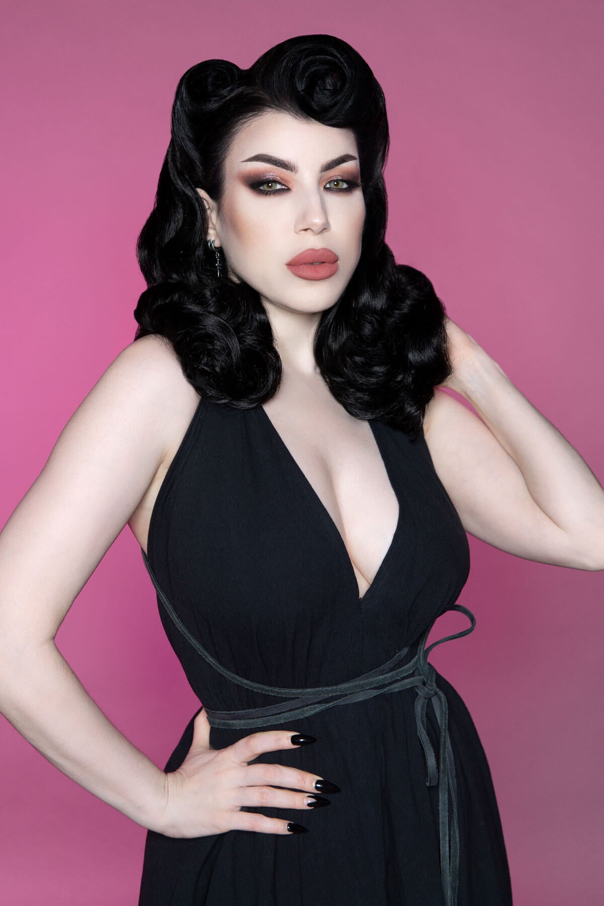 Woman in a black dress with a pink background. 1950s style shoulder length half wig hairpiece with beautiful vintage waves: Onyx dark brown 4
