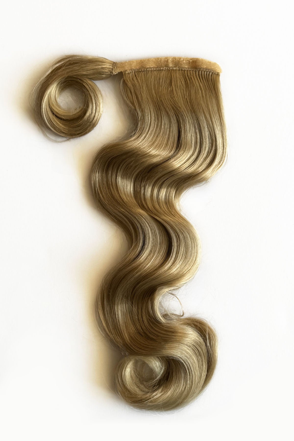 Blonde hair extension styled in loose waves on a white background. Long ponytail hairpiece with vintage waves: Kitrysha - blonde 613T24