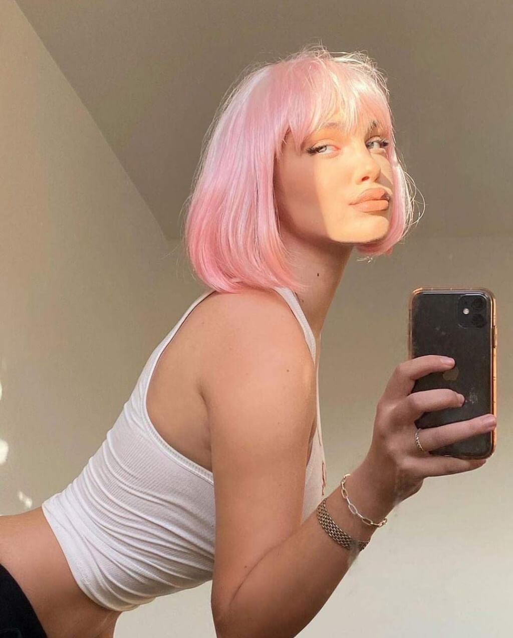 Person with pink hair taking a mirror selfie. Louisa - Sleek, Blunt, Classic Ombre Pink and Platinum Bob Wig