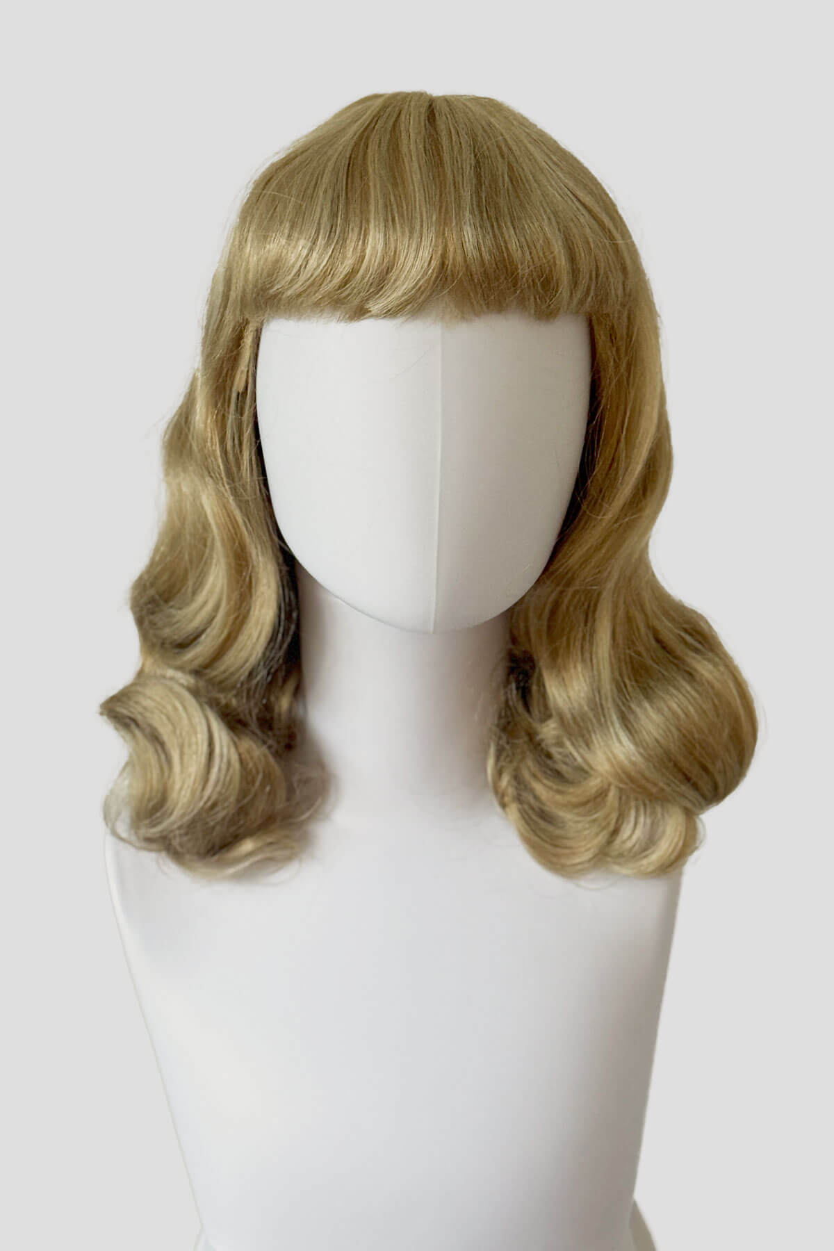 Blonde wig on a mannequin head against a white background. Blonde pinup wig with long finger waves and a short fringe: Cora Blonde 24H613