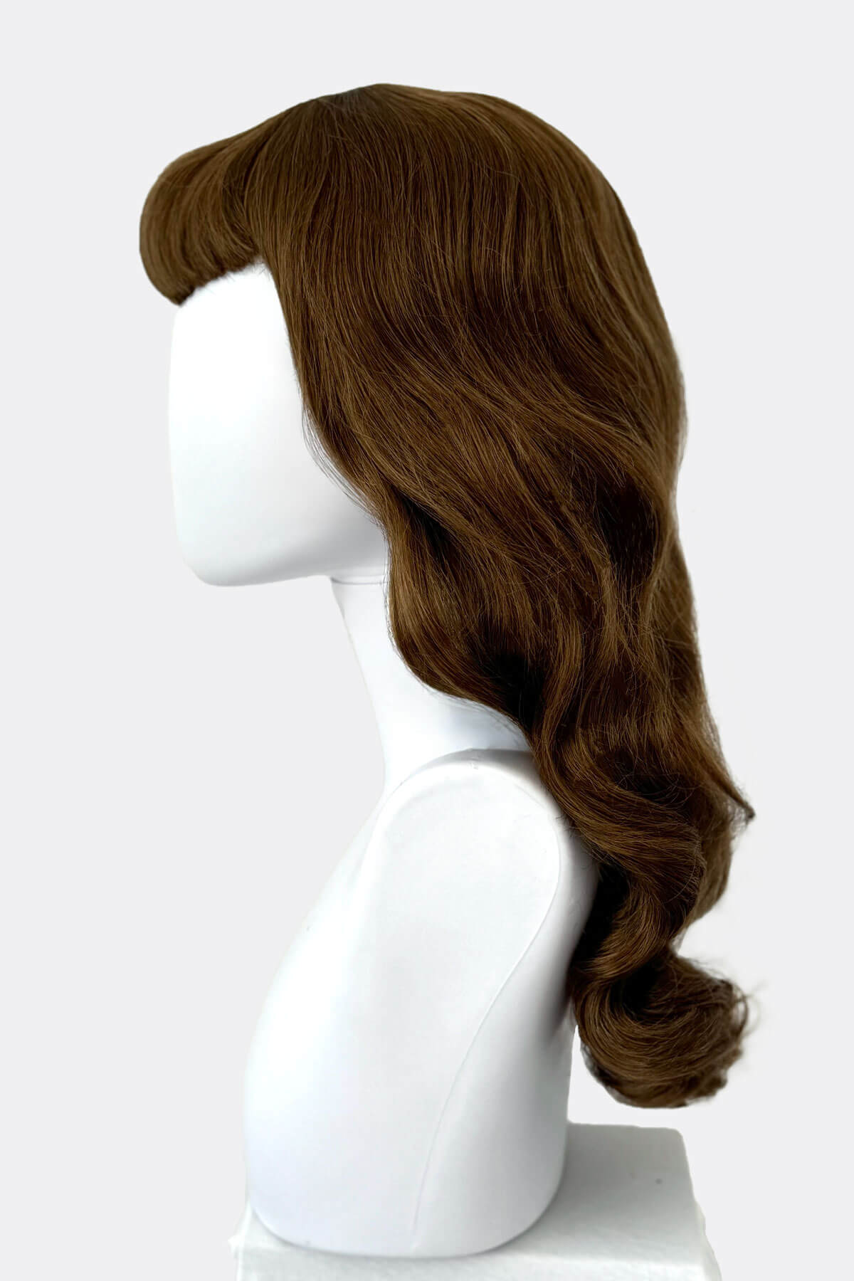 Brown wig on a white mannequin head against a white background. Brown 1950s pinup style wig, with long waves and a short fringe: Rosie golden brown 12-27
