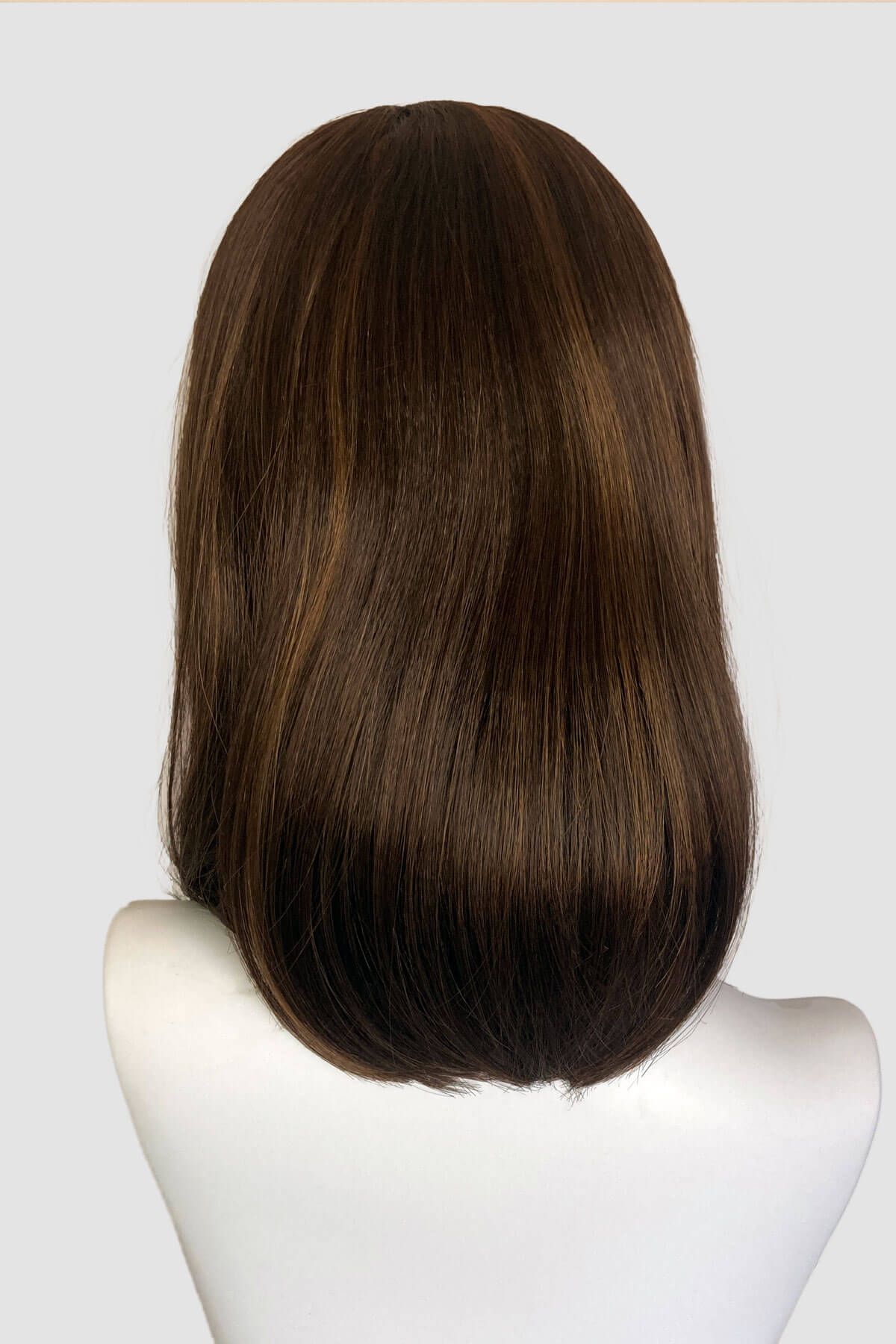 Brown wig on a mannequin head against a white background. Long bob wig with a short fringe, brown with blonde highlights: Jill 8H27