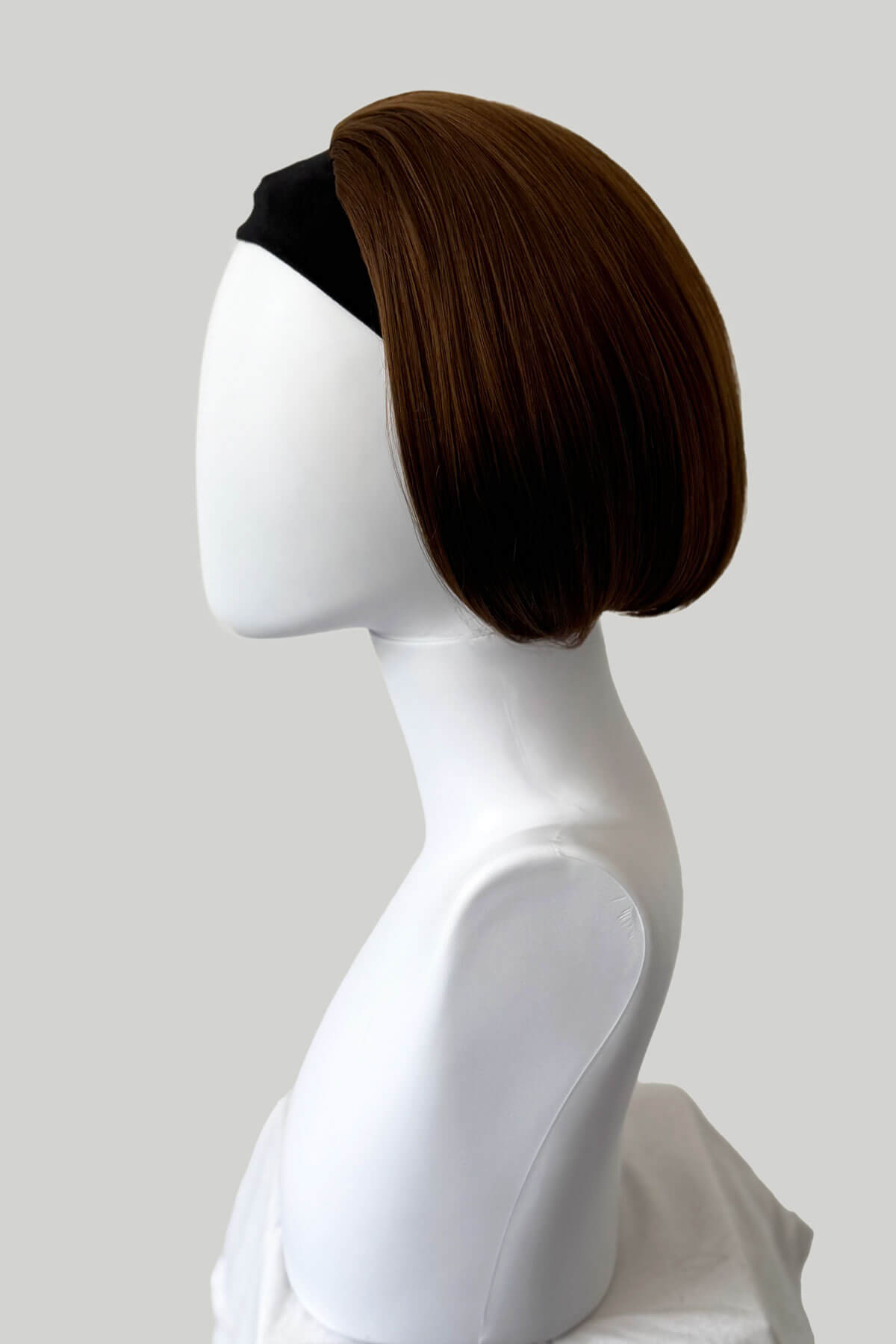 Brown wig on a white mannequin head against a gray background. Bob half wig hairpiece, heat styleable: Amelie light chocolate brown 12