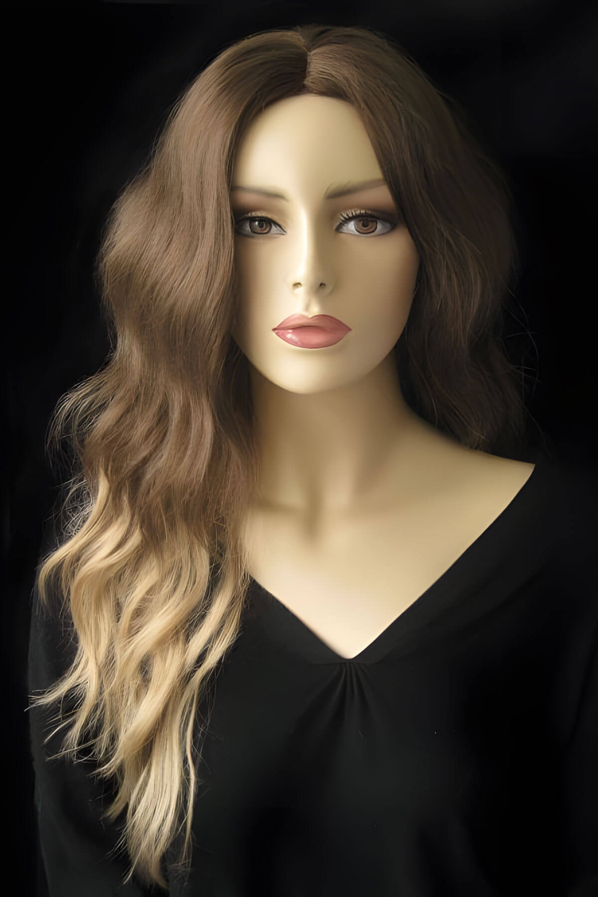 Mannequin head with long wavy brown hair on a black background. Dip dye chocolate brown and honey blonde wig long wavy wig with no fringe: Genevieve