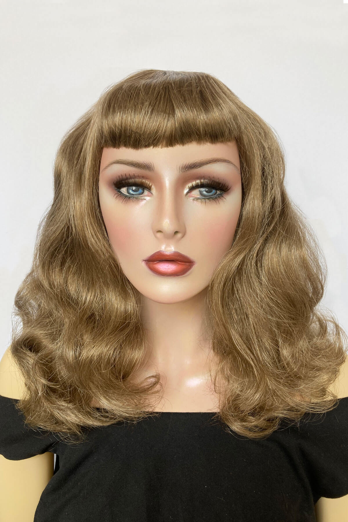 Mannequin head with long blonde wig on a white background. Brown & blonde 1950s pin up style wig, vintage waves, short fringe: Peggy