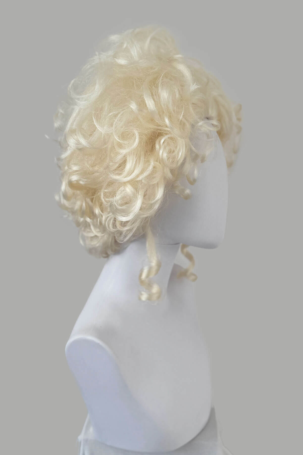 Blonde wig on a mannequin head against a gray background. Platinum blonde Marie Antoinette style wig: Marie platinum blonde 1001