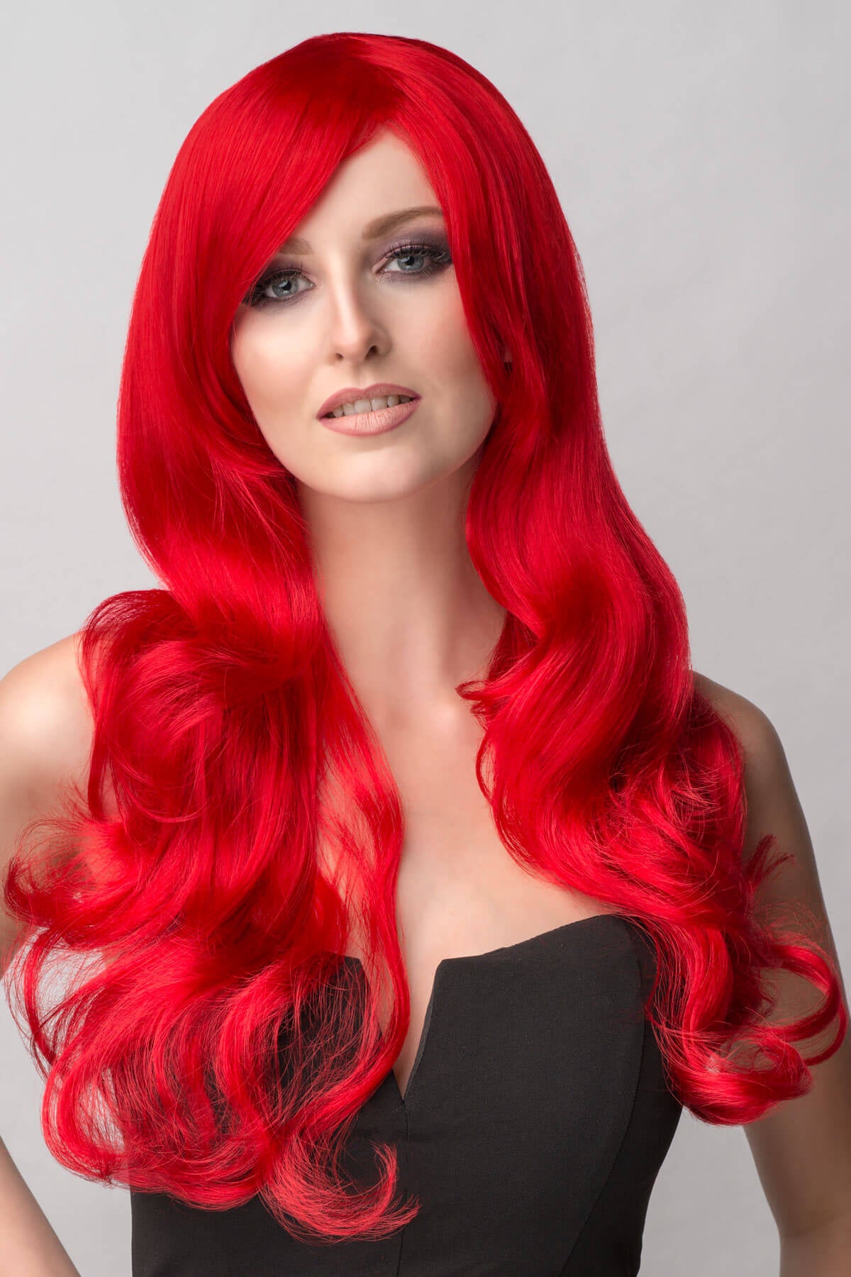 Person with long red wig on a plain background. Long bright red wig with long, big loose curls: Alexis