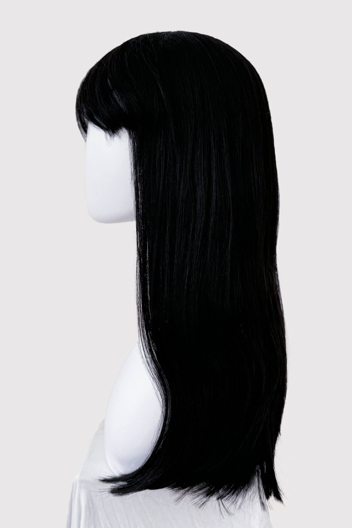 Black wig on a mannequin head against a white background. Long straight black wig with straight fringe: Carmen