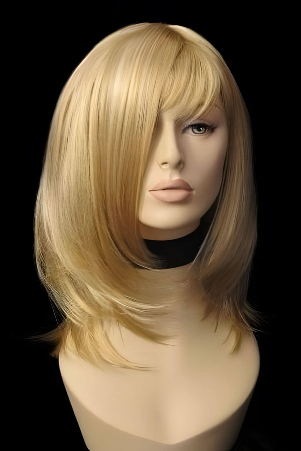 Blonde wig on a mannequin head against a black background