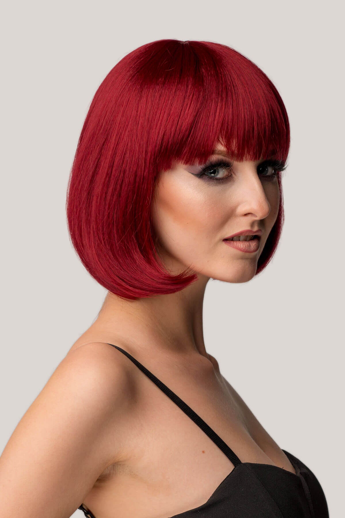 Woman with a stylish red bob haircut on a plain background
