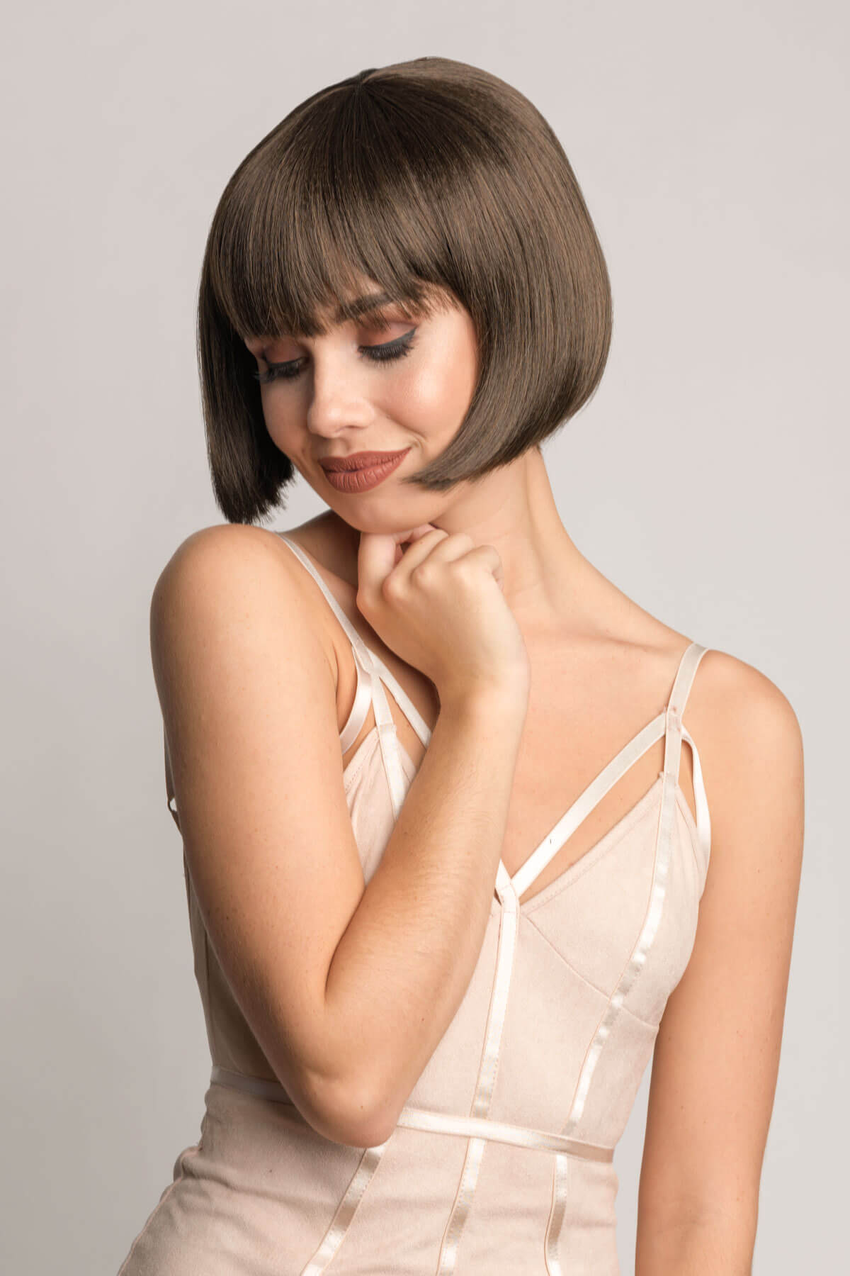 Woman with a stylish haircut posing against a plain background. Brown bob wig, chic and stylish: Honour chestnut brown 8