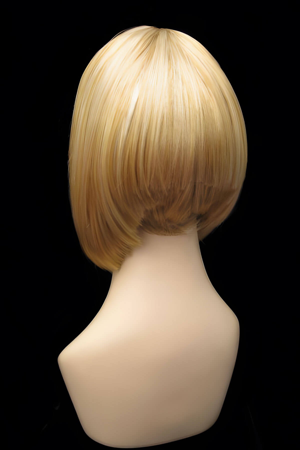 Blonde wig on a mannequin head against a black background. Blonde inverted bob wig: Rhiannon honey blonde 24BH613