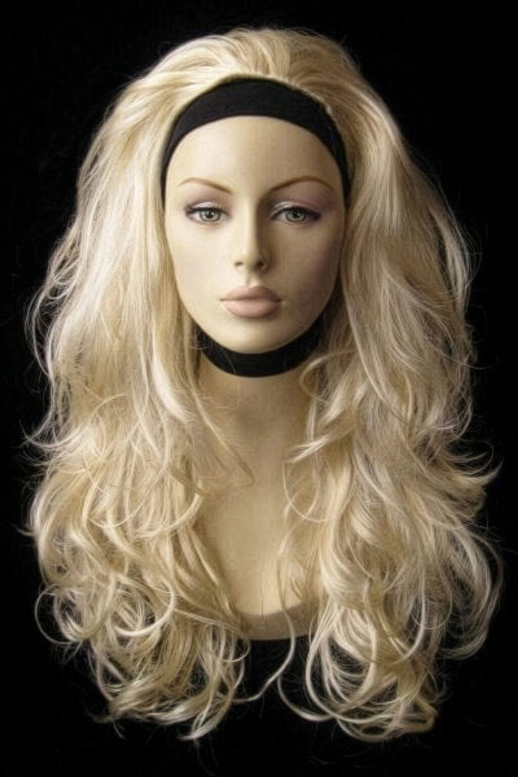 Blonde wig on a mannequin head against a black background. Long blonde 3/4 hairpiece (half wig), big loose curls: Zara creamy blonde 613