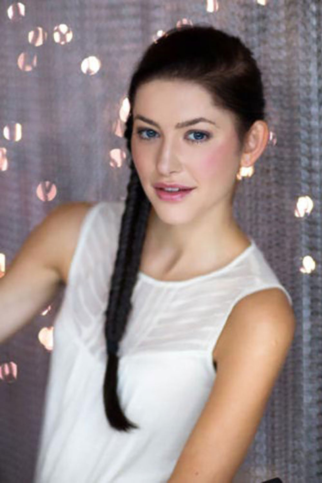A woman wearing a white top showcasing a fishtail plait hairpiece extension. Fishtail plait (braid) hairpiece extension: Tinsley