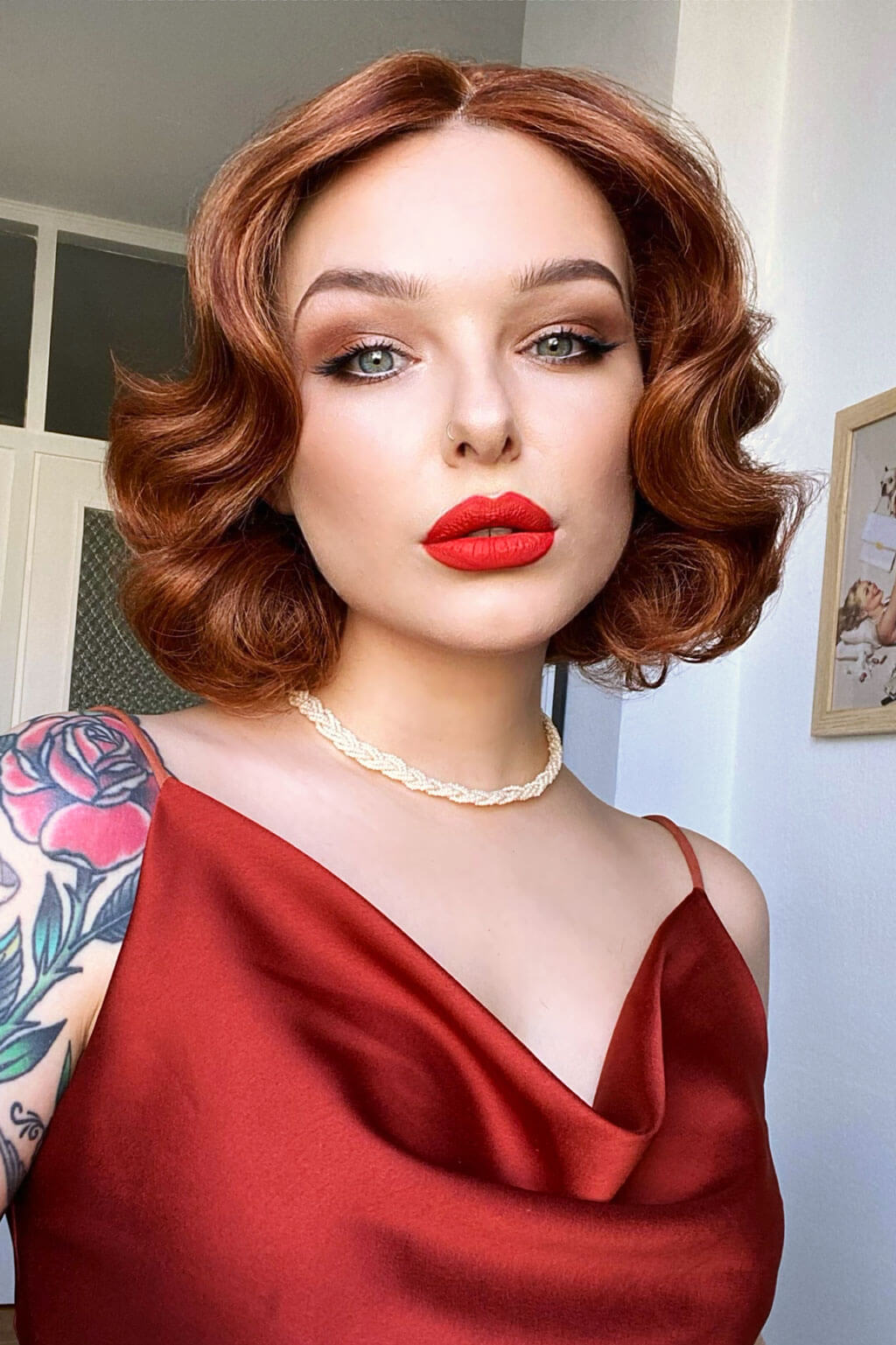 Woman with red hair and red lipstick wearing a red dress indoors. Red, auburn & blonde pinup wig, lace front, vintage style: Ginny